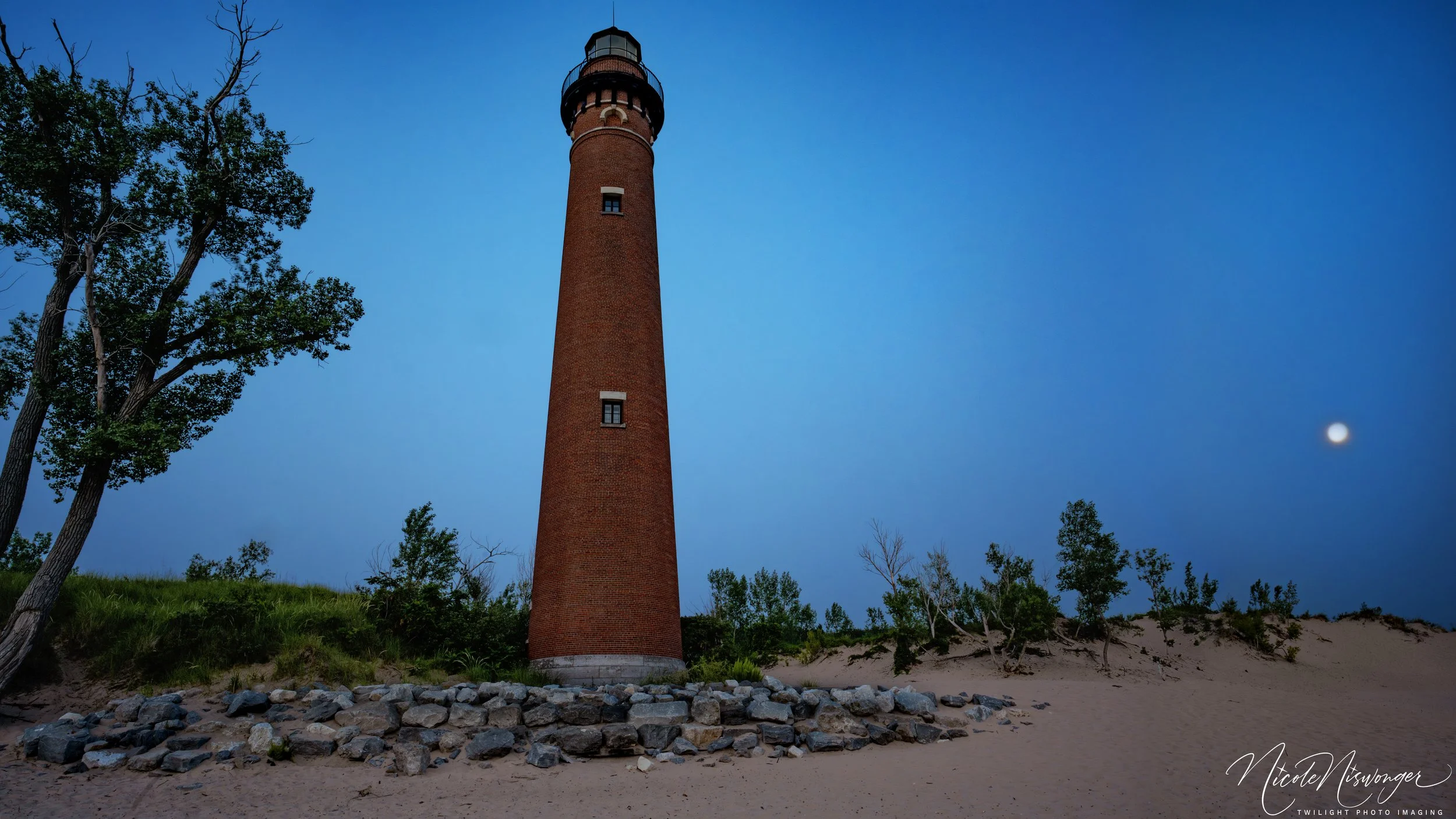 Little Sable Lighthouse aside a full moon in August 2025.