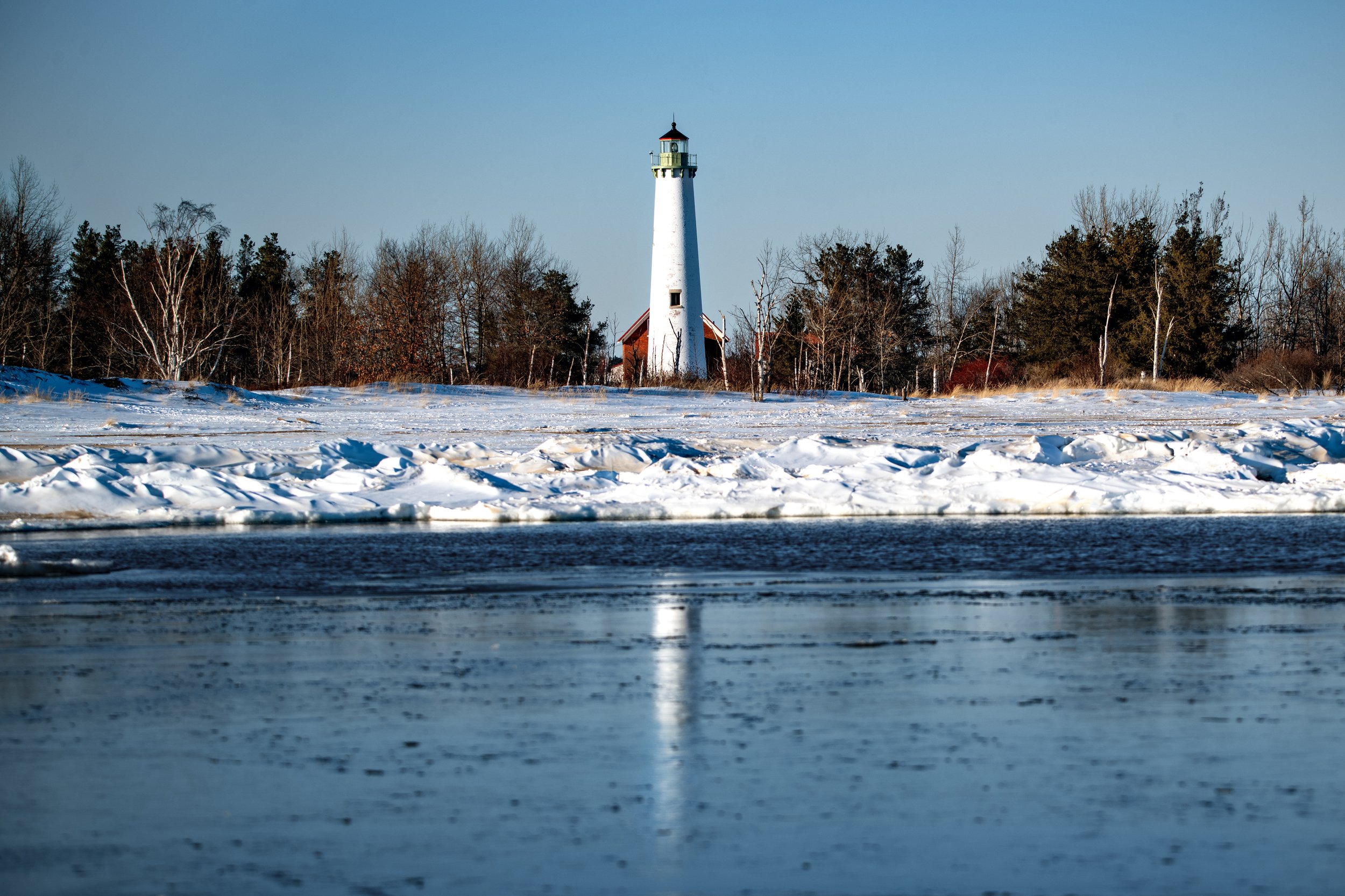 Tawas Point Lighthouse reflecting on the water in February 2026.