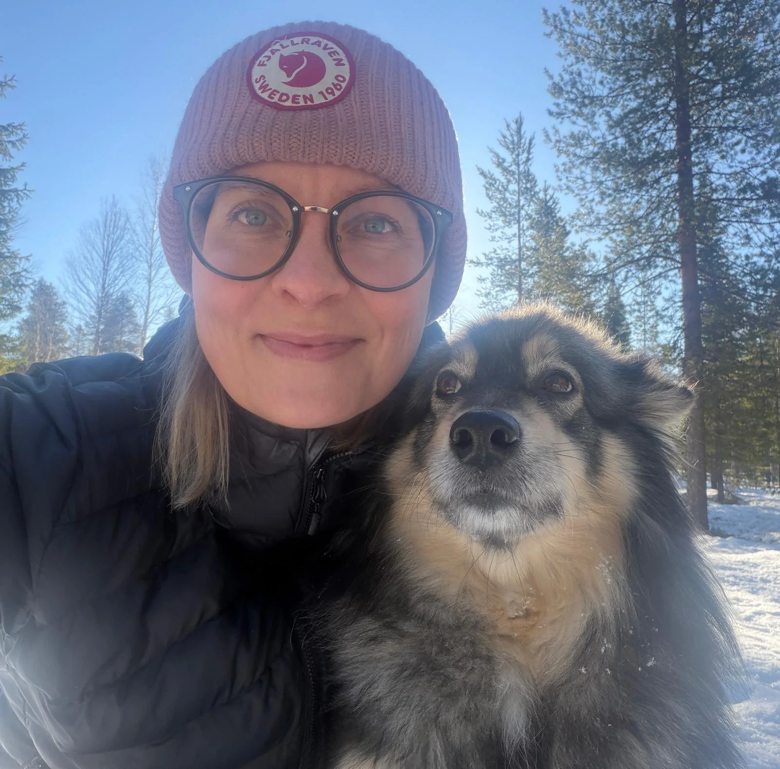 Henkilö ja koira ulkona luonnossa rauhallisessa ympäristössä.