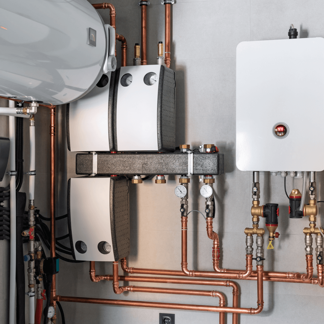 Indoor plumbing system with copper pipes, gauges, and a water heater mounted on a wall.