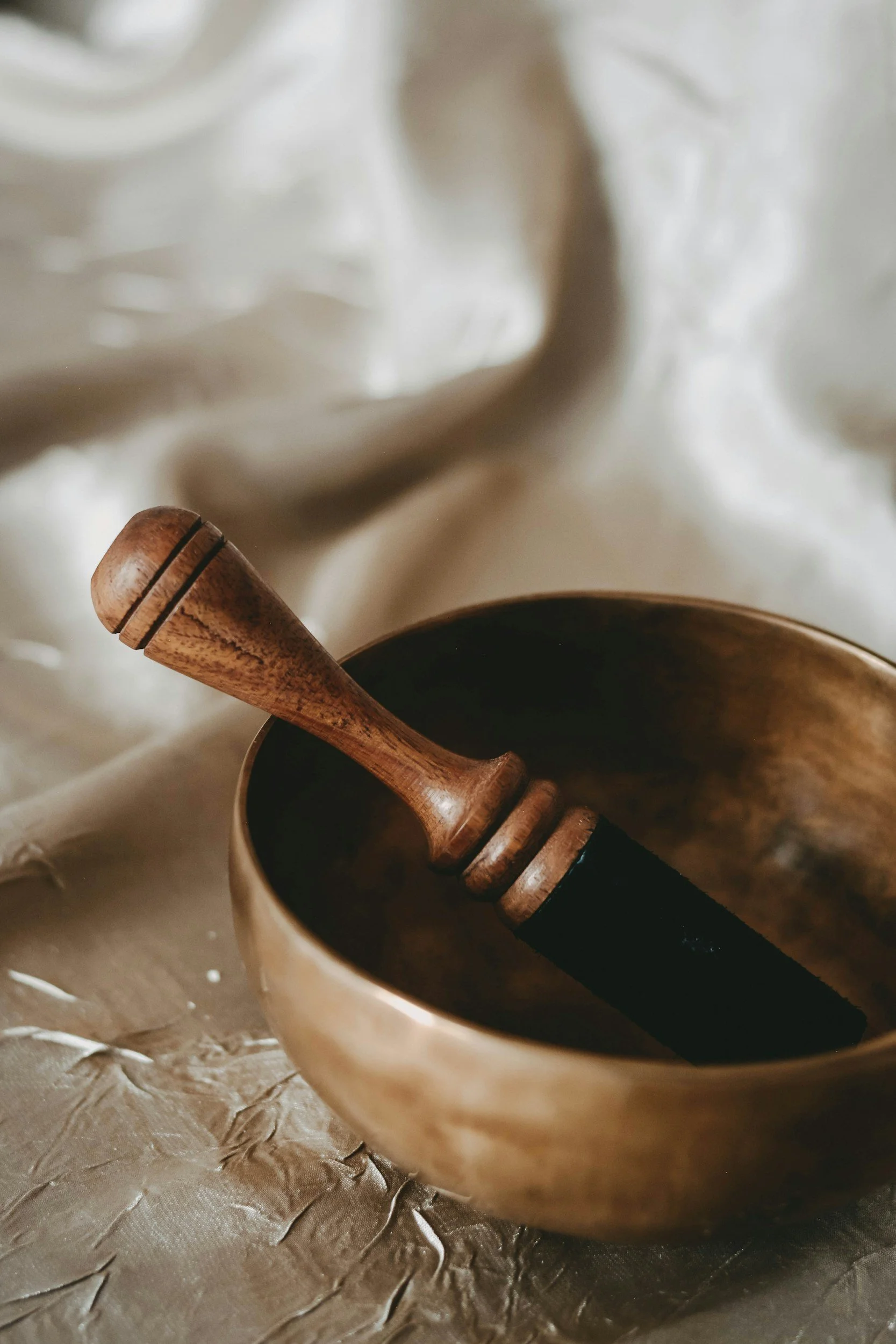 A wooden honey dipper resting inside a ceramic bowl.