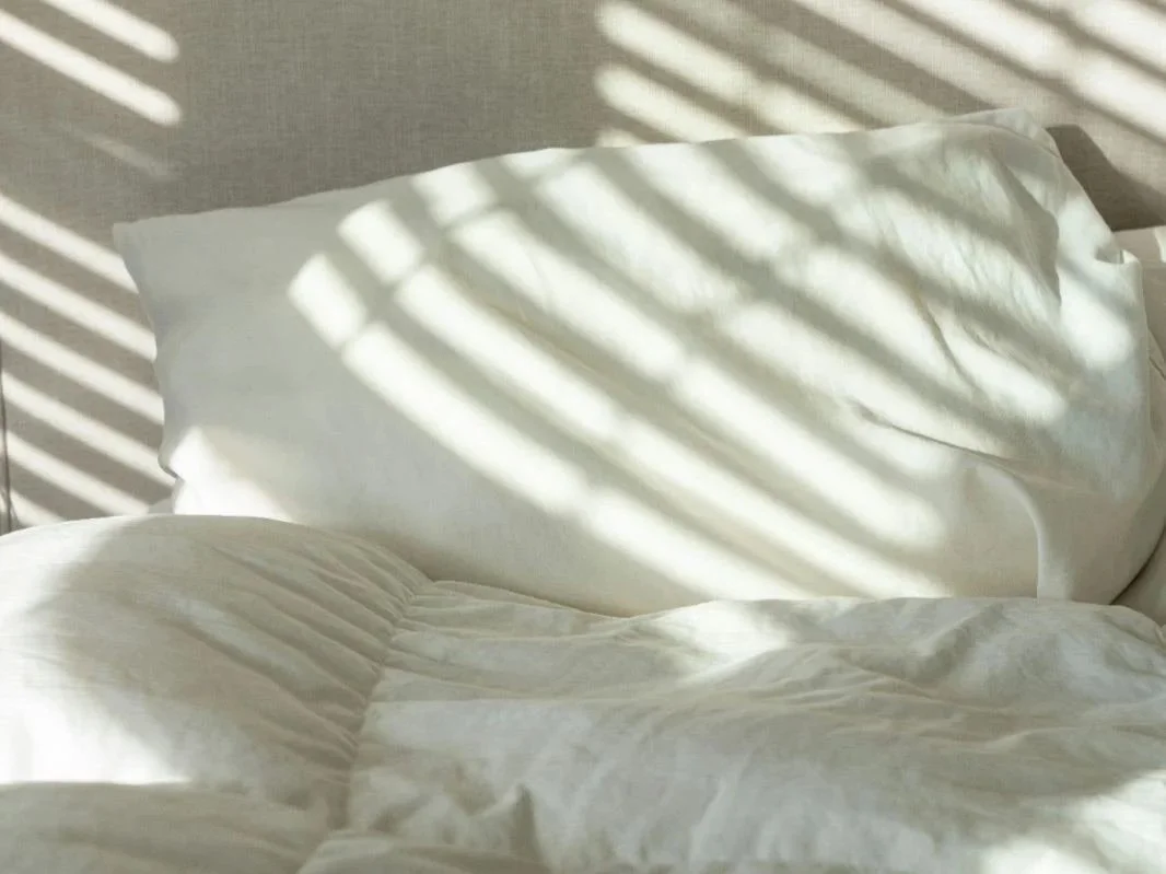Lit blanc défait avec rayons de soleil