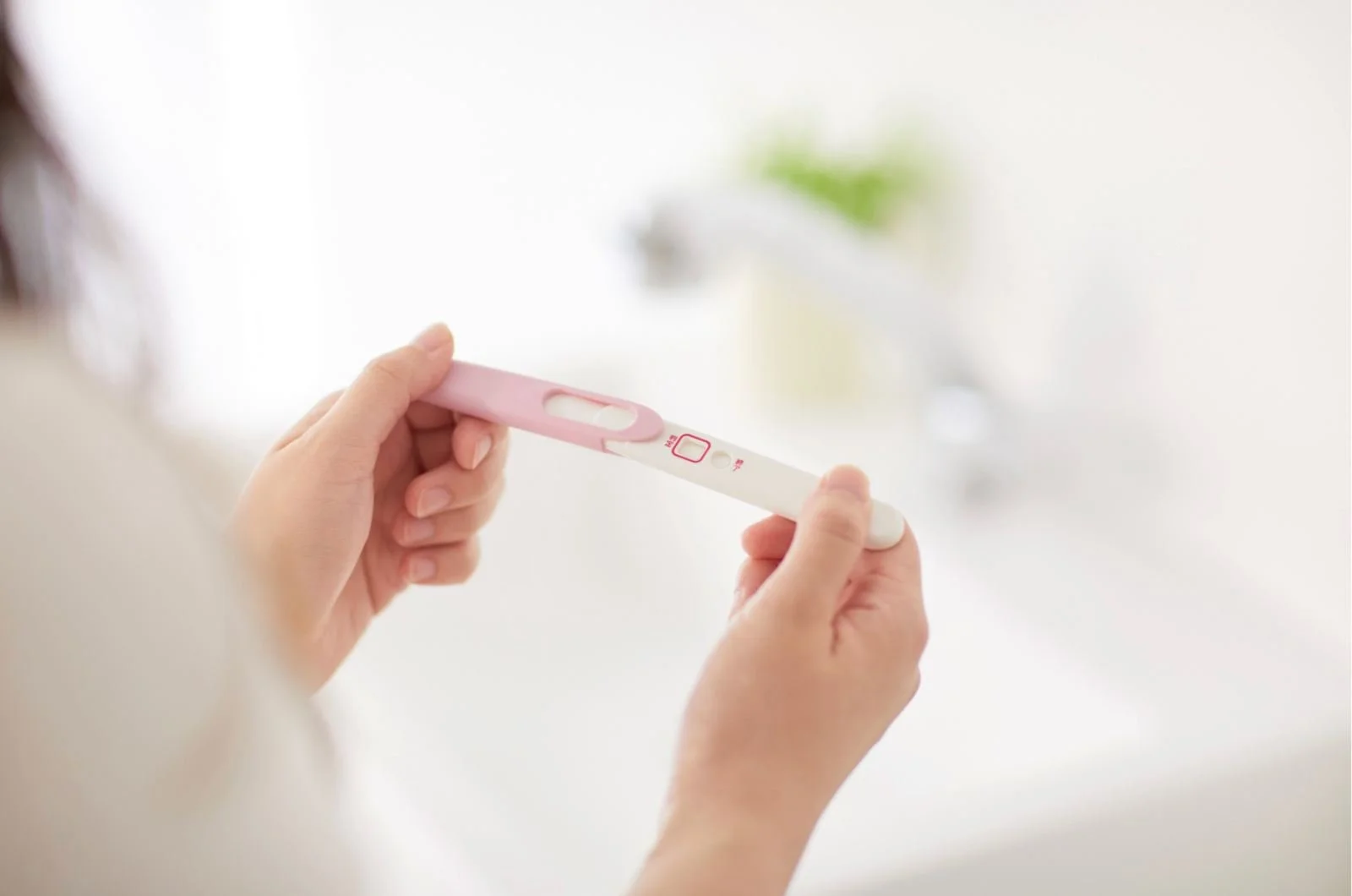 Femme qui tient un test de grossesse
