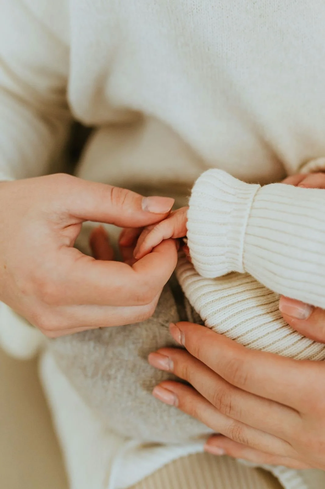 Une femme tient la petite main d'un bébé dans sa main