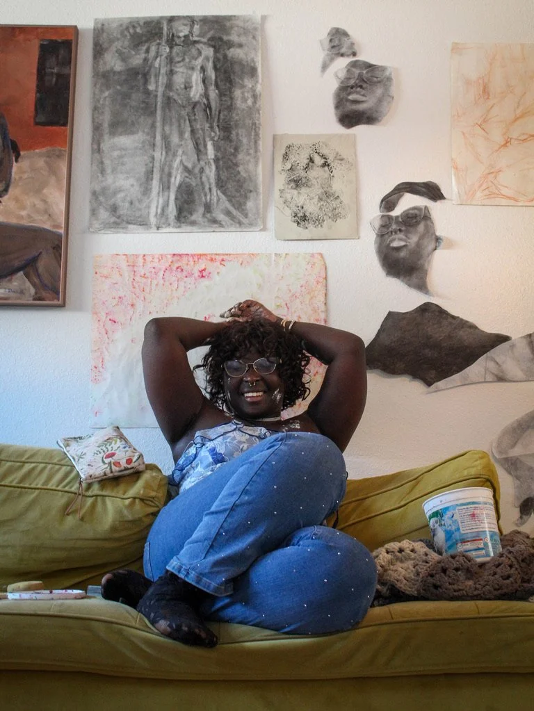 University of North Texas Senior Khadeeja Lamin poses with her art in her apartment in Denton, Texas on Wednesday, April 8, 2026. Lamin is a Studio Arts Major and wants to continue creating their charcoal drawings after she graduates. (photo by Genev
