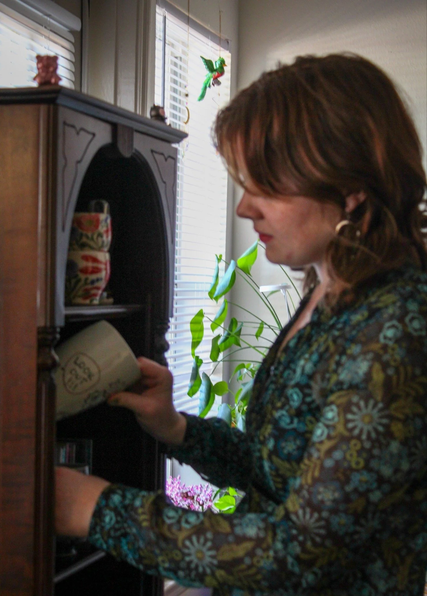 Mug Collections - 22-year-old Kat Hardy puts away one of her handmade mugs back into a hutch her roommate found in Denton on Saturday, May 2, 2026. Both Hardy and her roommate are ceramic majors, so their home is filled with mugs and knickknacks. (ph