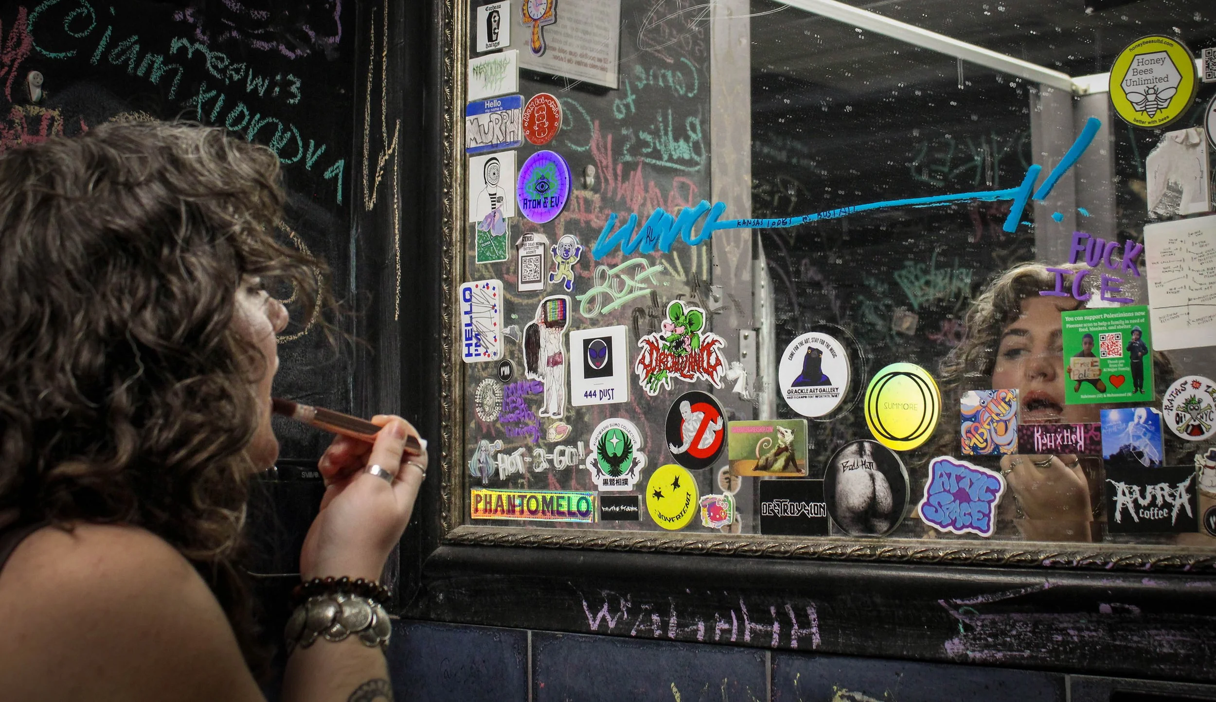 University of North Texas Senior Sammy Lane puts lipstick on in the bathroom of Rubber Gloves in Denton, Texas on Tuesday, Feb. 17, 2026. Lane was waiting for the band Bladda to perform at 8:30 p.m. with her two friends. (photo by Genevieve Kaufmann)