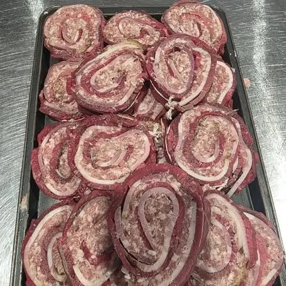 Slices of raw bacon arranged on a tray.