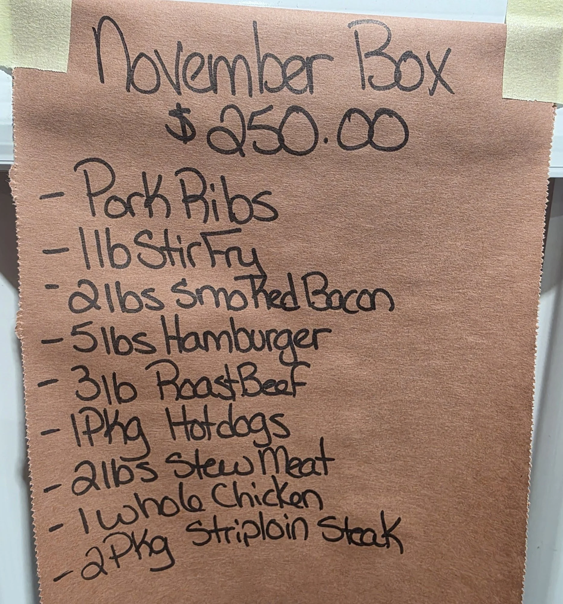 Handwritten shopping list for a November Box, priced at $250, including pork ribs, 1 lb stir fry, 2 lbs smoked bacon, 5 lbs hamburger, 3 lb roast beef, 17 lb hot dogs, 21 lbs stew meat, whole chicken, and 2 kg striploin steak.
