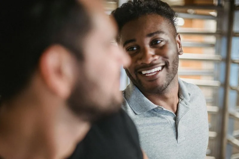One man looking at another and smiling