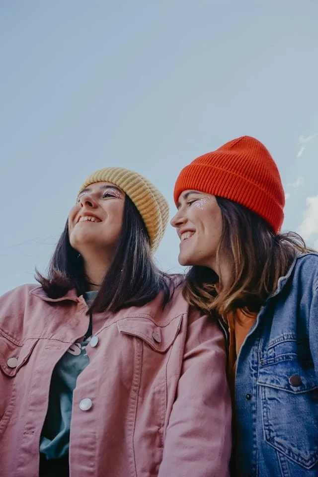 Two women with knit hats on smiling