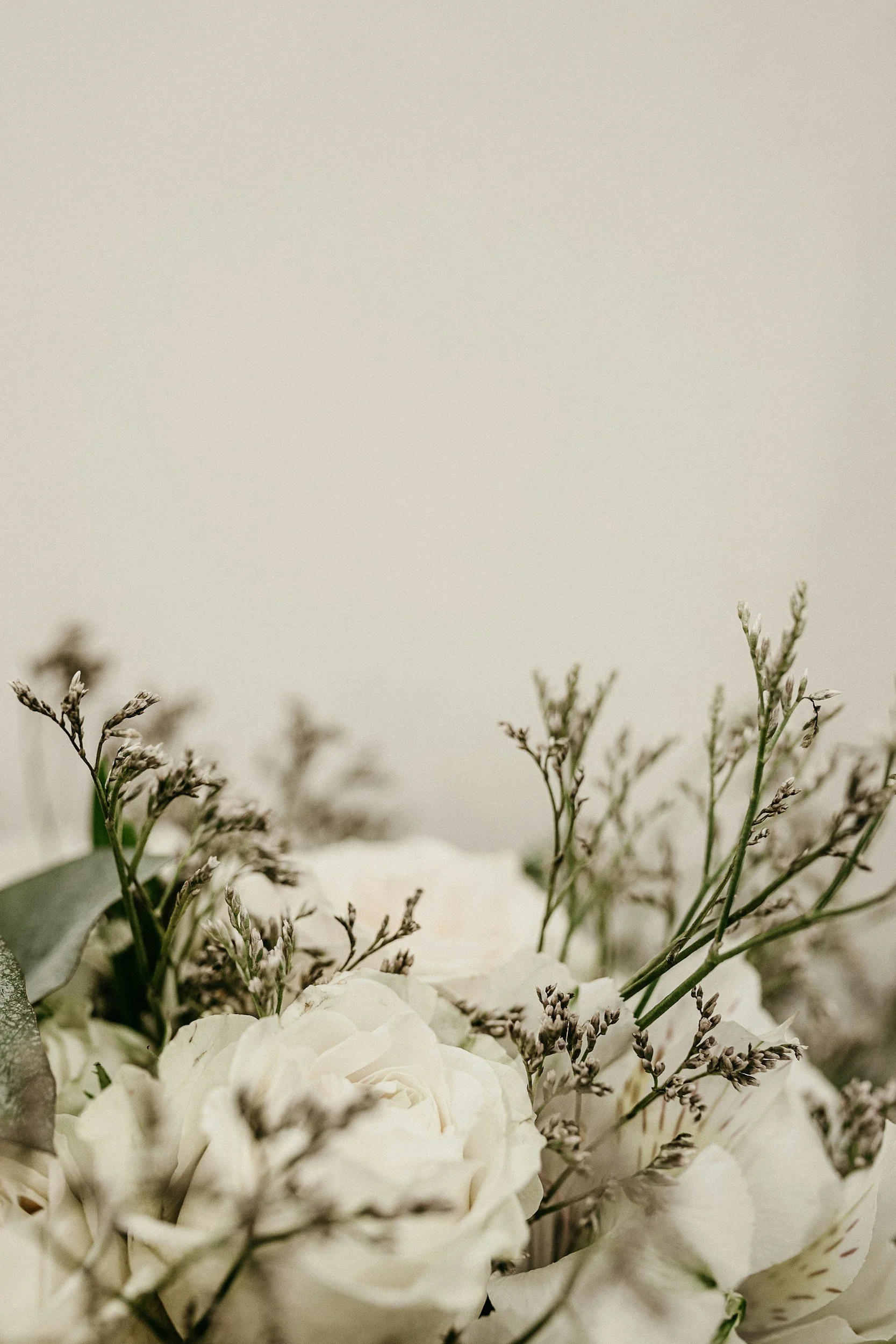 A floral arrangement with white flowers and green foliage.