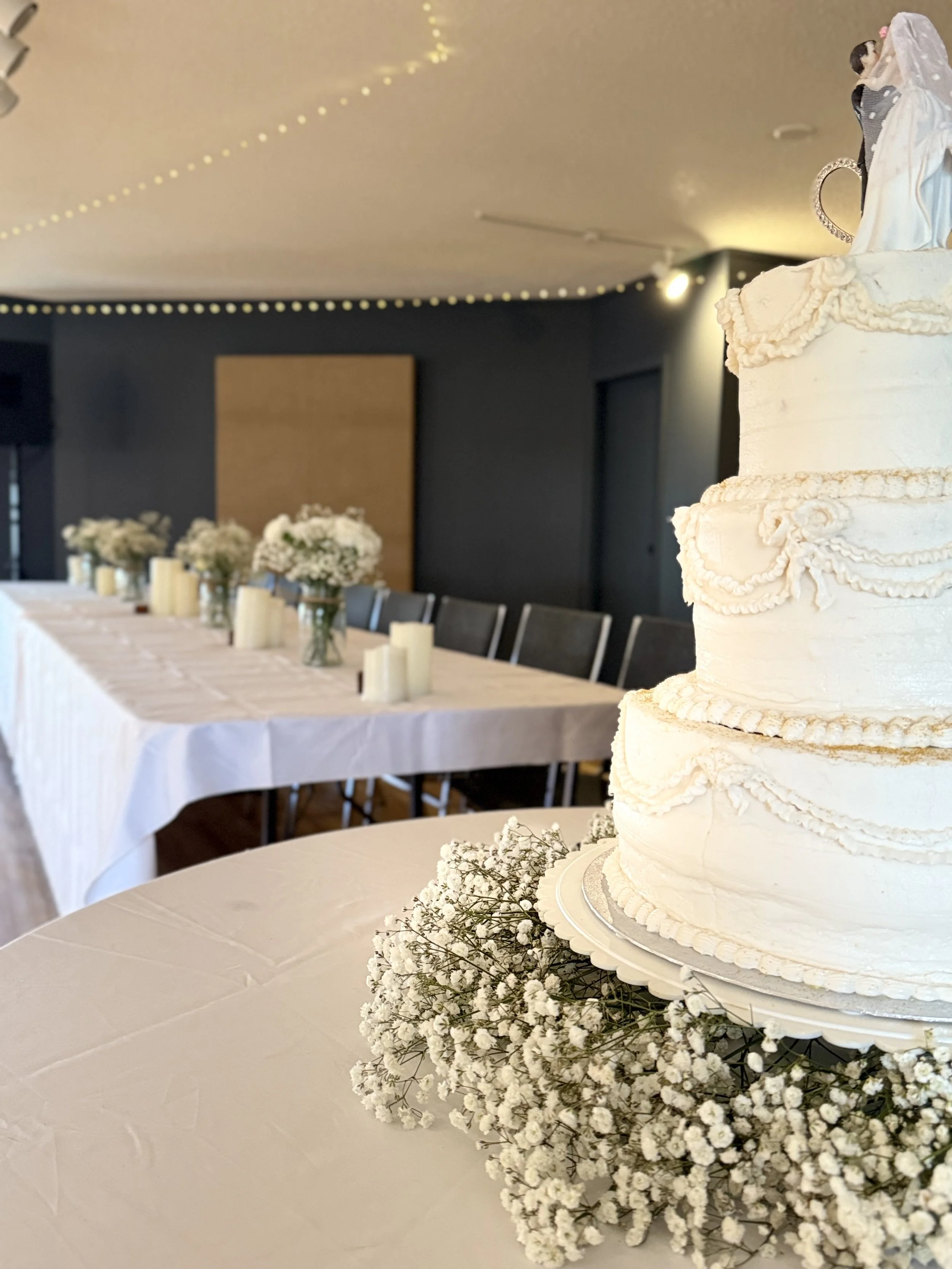 Three tier wedding cake and wedding reception head table at Open Country Farm wedding venue near Red Deer Alberta