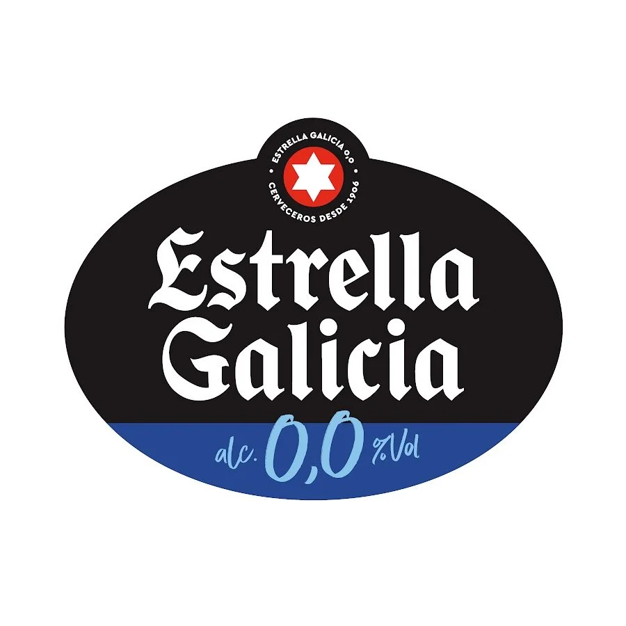 Etiqueta de cerveza Estrella Galicia sin alcohol, con el logo de la marca, fondo blanco y detalles en negro, rojo y azul.