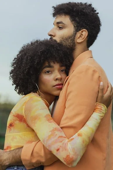 Couple embracing but looking away from each other — couples therapy for disconnection in Muskegon West Michigan