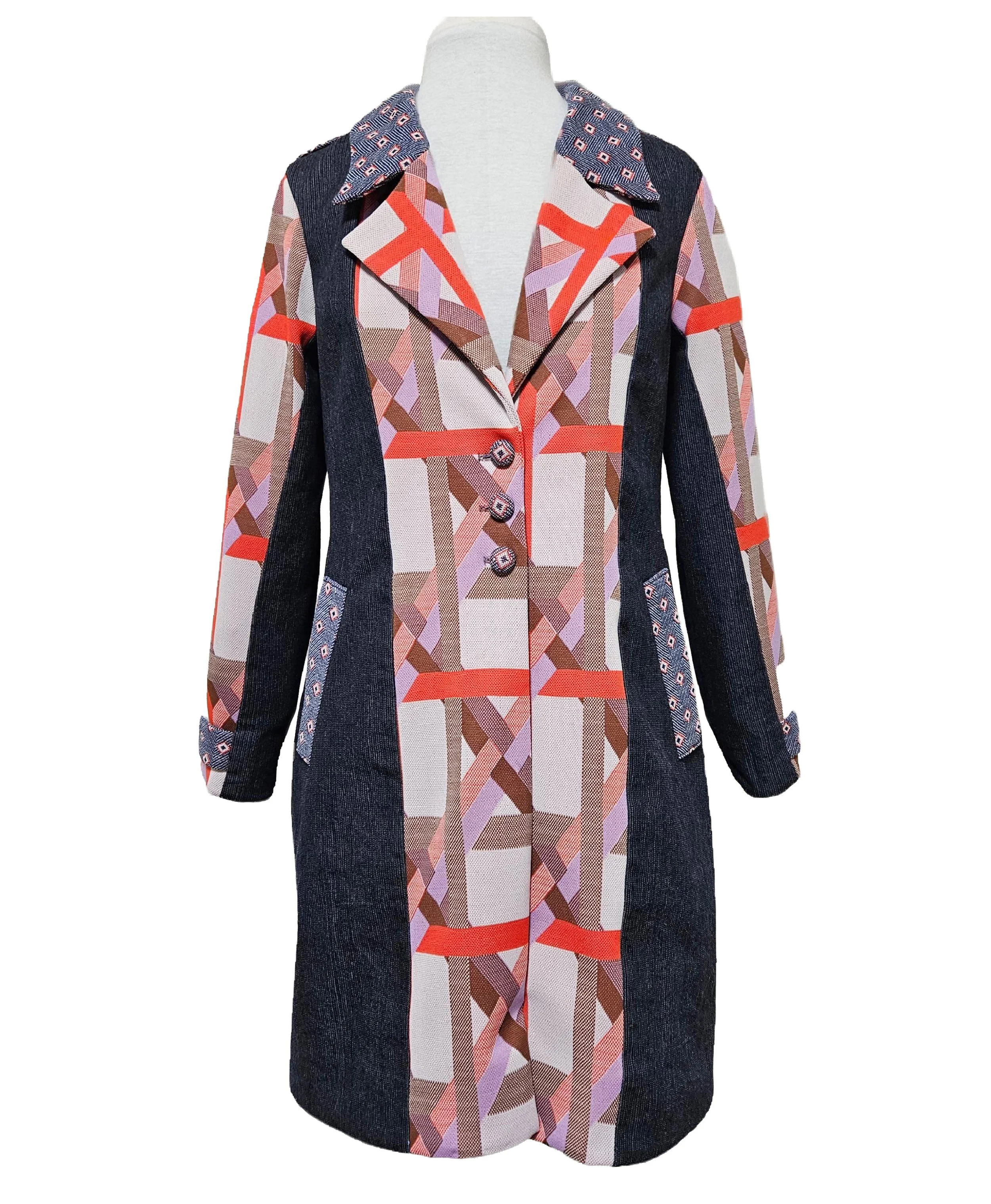 A long, colorful, retro patterned coat with geometric designs and contrasting fabric panels on the sides and sleeves, displayed on a mannequin. Custom design.