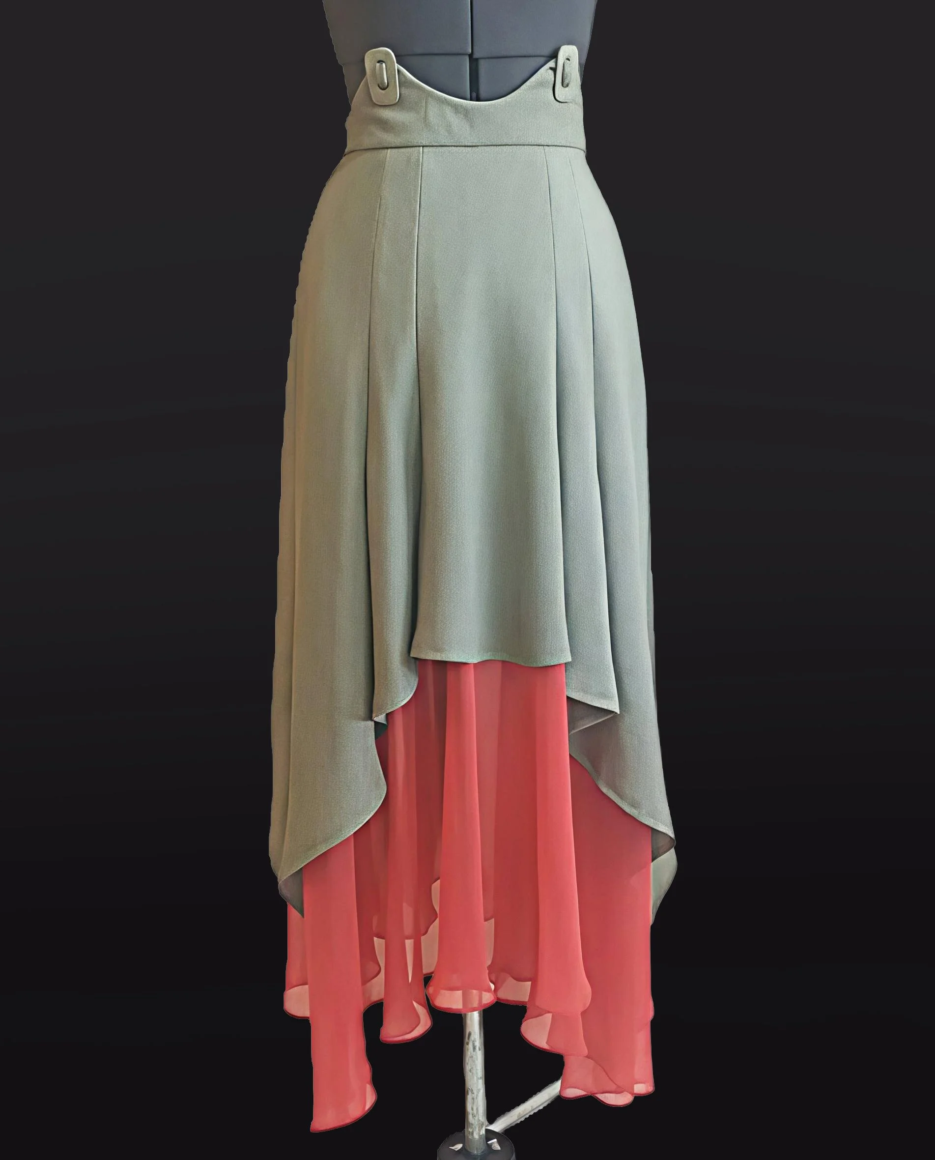 A mannequin display wearing a high-waisted beige skirt with layered pink chiffon fabric underneath, styled against a plain black background.