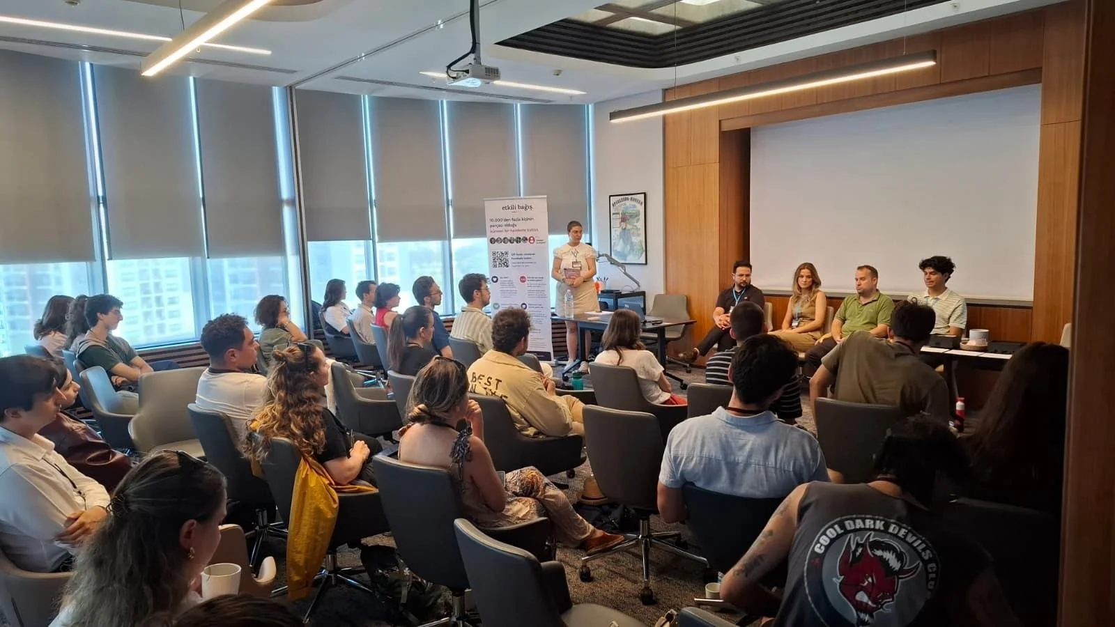 Conference room with seated audience and a panel of speakers