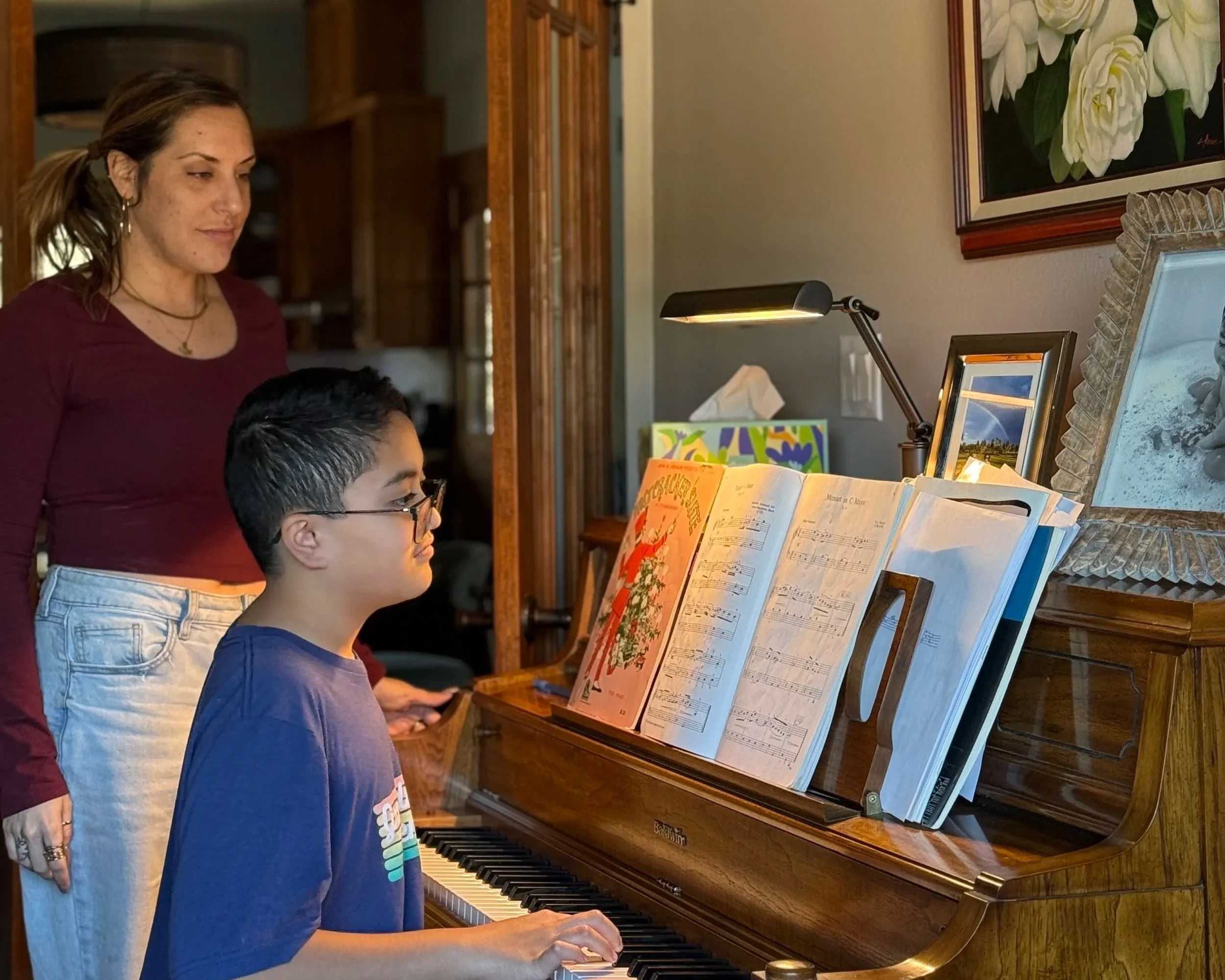 Alex at the piano with 10-year old Danny during their in-home piano lesson.