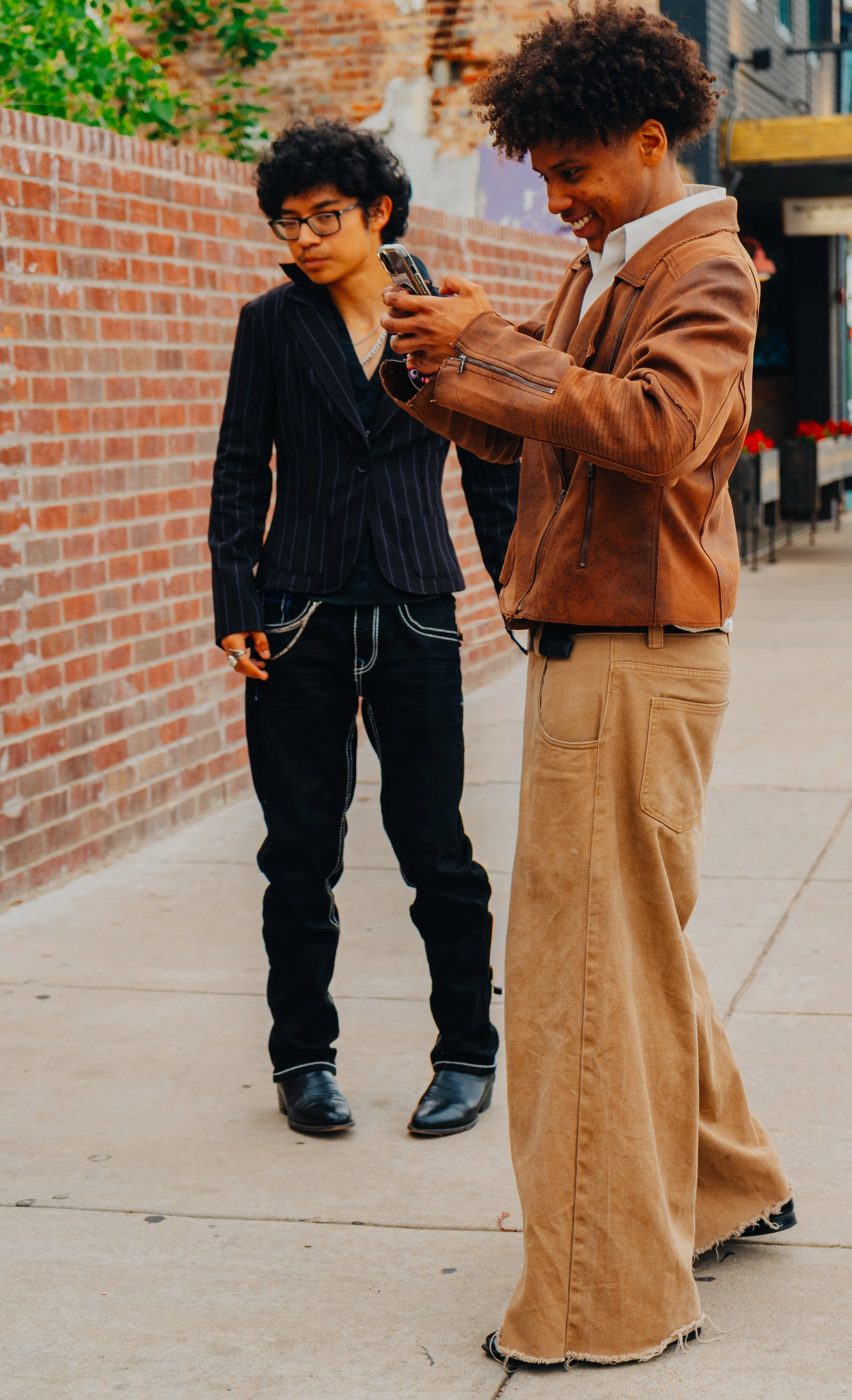 Fashionably Late
-
Denton resident Ethan Belcon smiles while looking at a photo taken by a friend on N Locust St in Denton Square. Belcon and friends worked on outfits for modeling, using the Square as a place for photos.