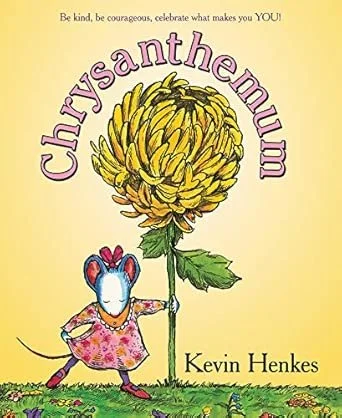 Children's book cover for 'Chrysanthemum' by Kevin Henkes, featuring a large yellow chrysanthemum flower and a mouse in a pink floral dress, standing on green grass with a yellow background. The text says, 'Be kind, be courageous, celebrate what makes you YOU!'