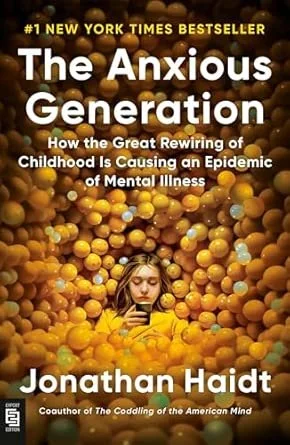 Book cover of 'The Anxious Generation' by Jonathan Haidt, featuring a young girl surrounded by yellow balls, looking at her phone.