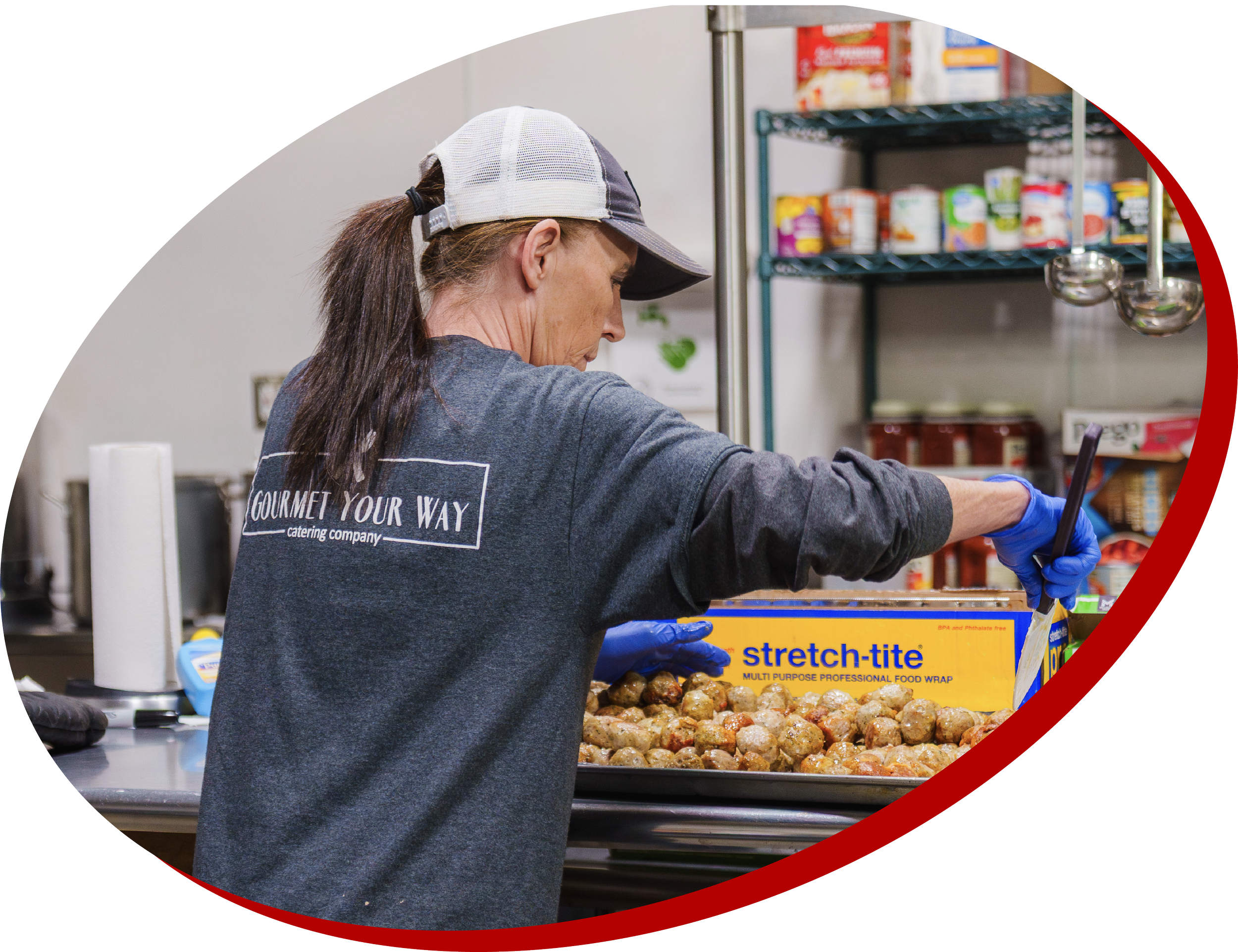 Woman in catering kitchen cooking meatballs
