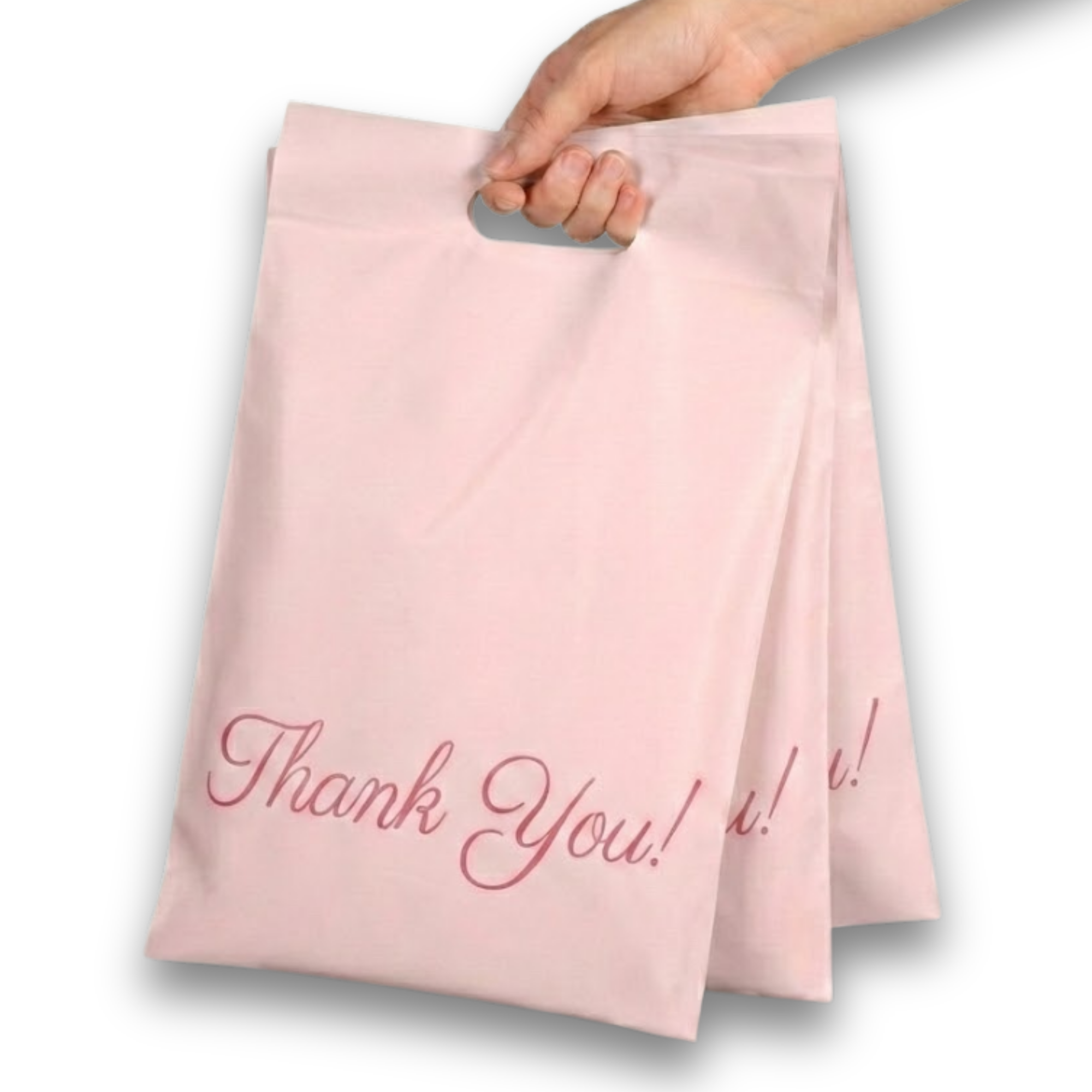 A hand holds pink paper gift bags with 'Thank You!' written on them in cursive.