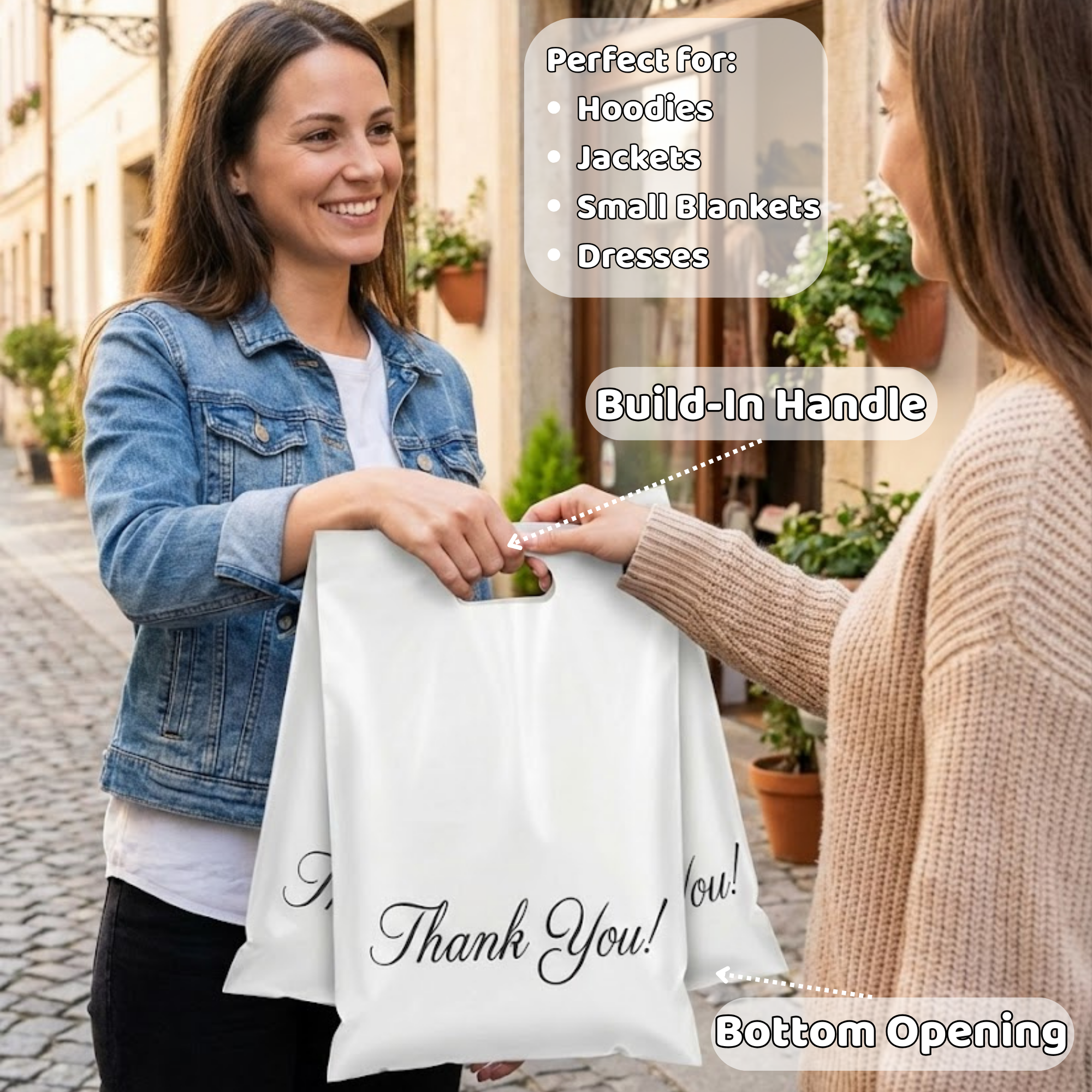 Two women exchanging a white gift bag with a built-in handle and 'Thank You!' written on it, on a cobblestone street with storefronts and potted plants. One woman is smiling and handing the bag to the other, who is holding it with her hand. There are text overlays describing the bag's features, such as build-in handle, suitable for hoodies, jackets, small blankets, and dresses, and bottom opening.