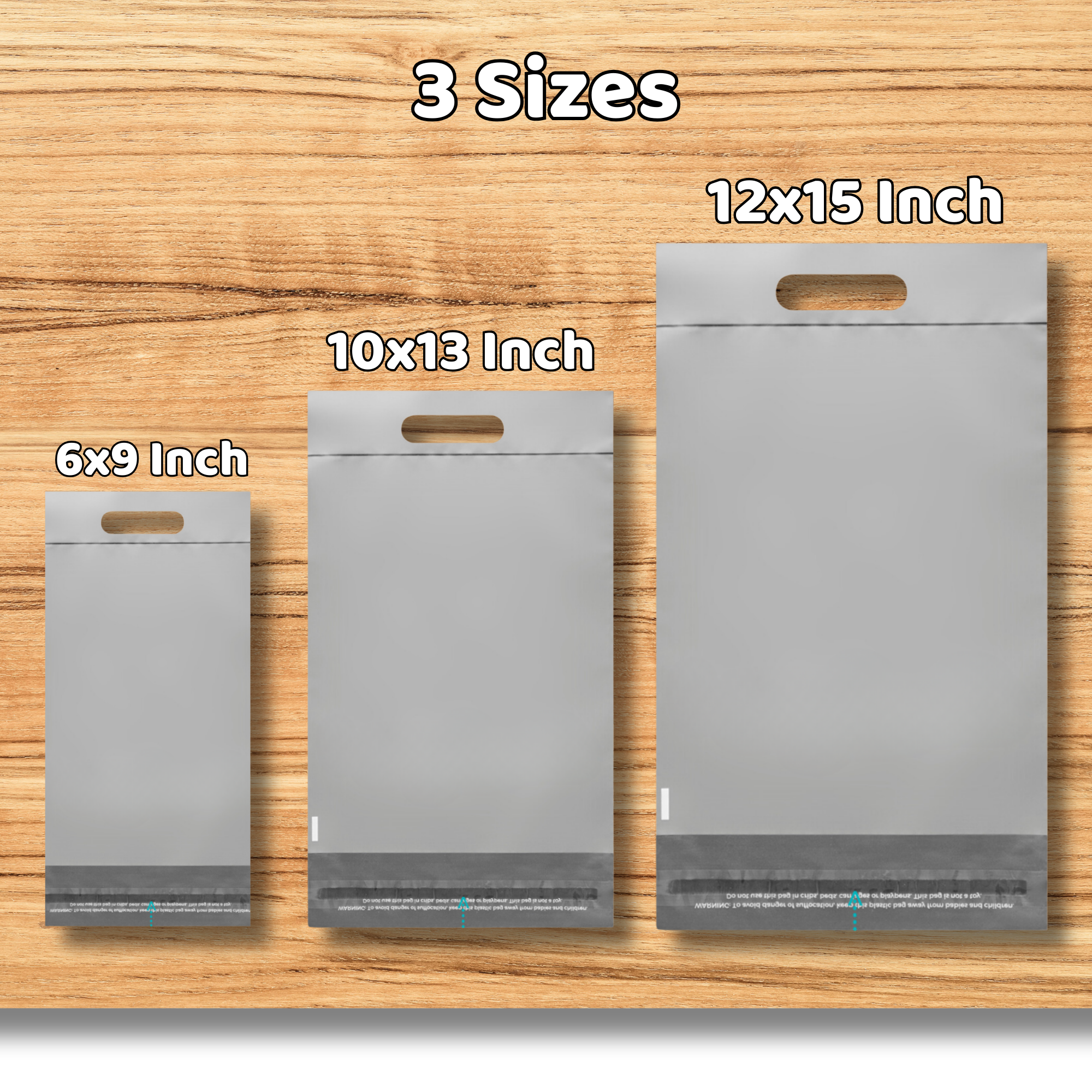 Three different sizes of gray plastic bags with die-cut handles are displayed on a wooden surface. The sizes are labeled as 6x9 inches, 10x13 inches, and 12x15 inches, from smallest to largest.