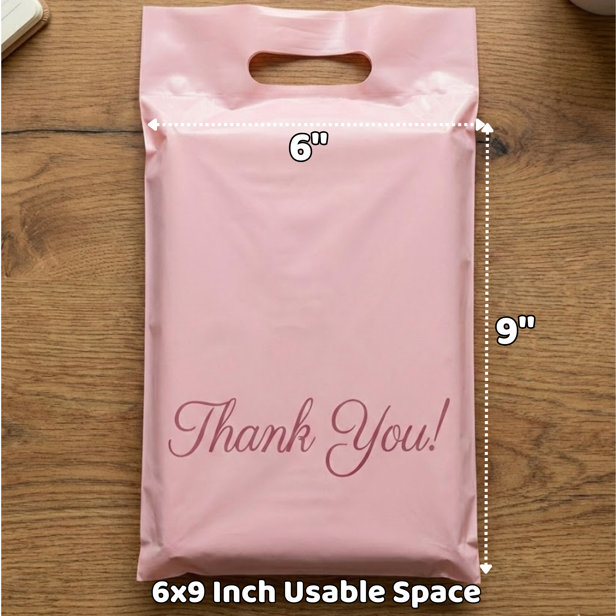 Pink plastic gift bag with a die-cut handle, measuring 6 inches wide and 9 inches tall, featuring the words "Thank You!" in cursive font on the front.
