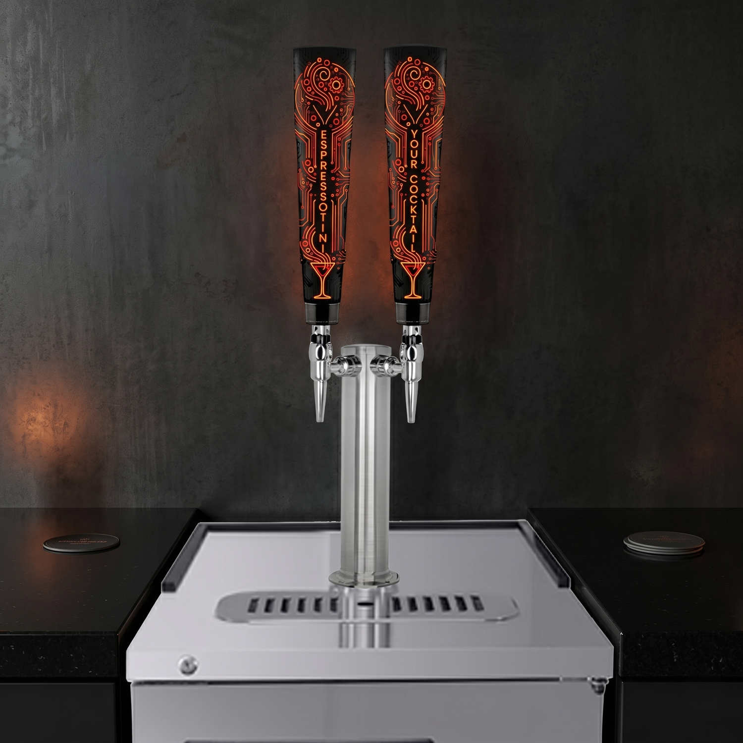 A beverage dispenser with two black pistons featuring orange circuit board patterns and the words "Espresso in" and "Your Cocktail". It is set against a dark background with a white drip tray and black countertop.