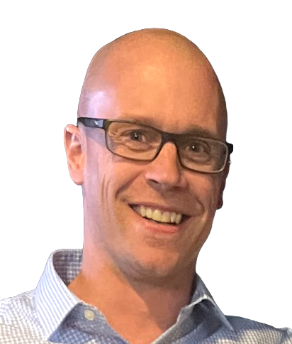 A smiling man with glasses and a light blue checkered shirt, against a black background.
