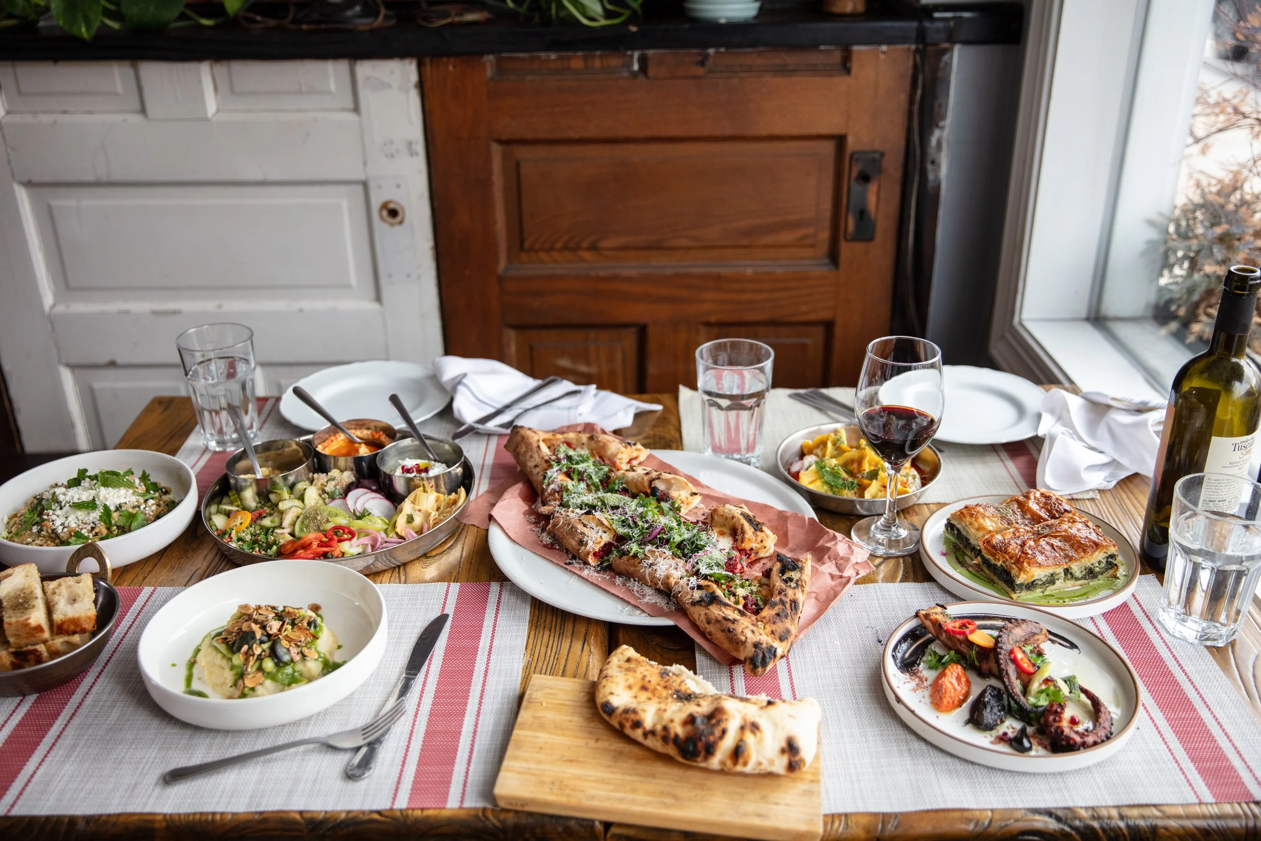 Dinner Table with Pide, Braised Snails, Octopus, Hummus. Baba Ghanouj, Dumplings