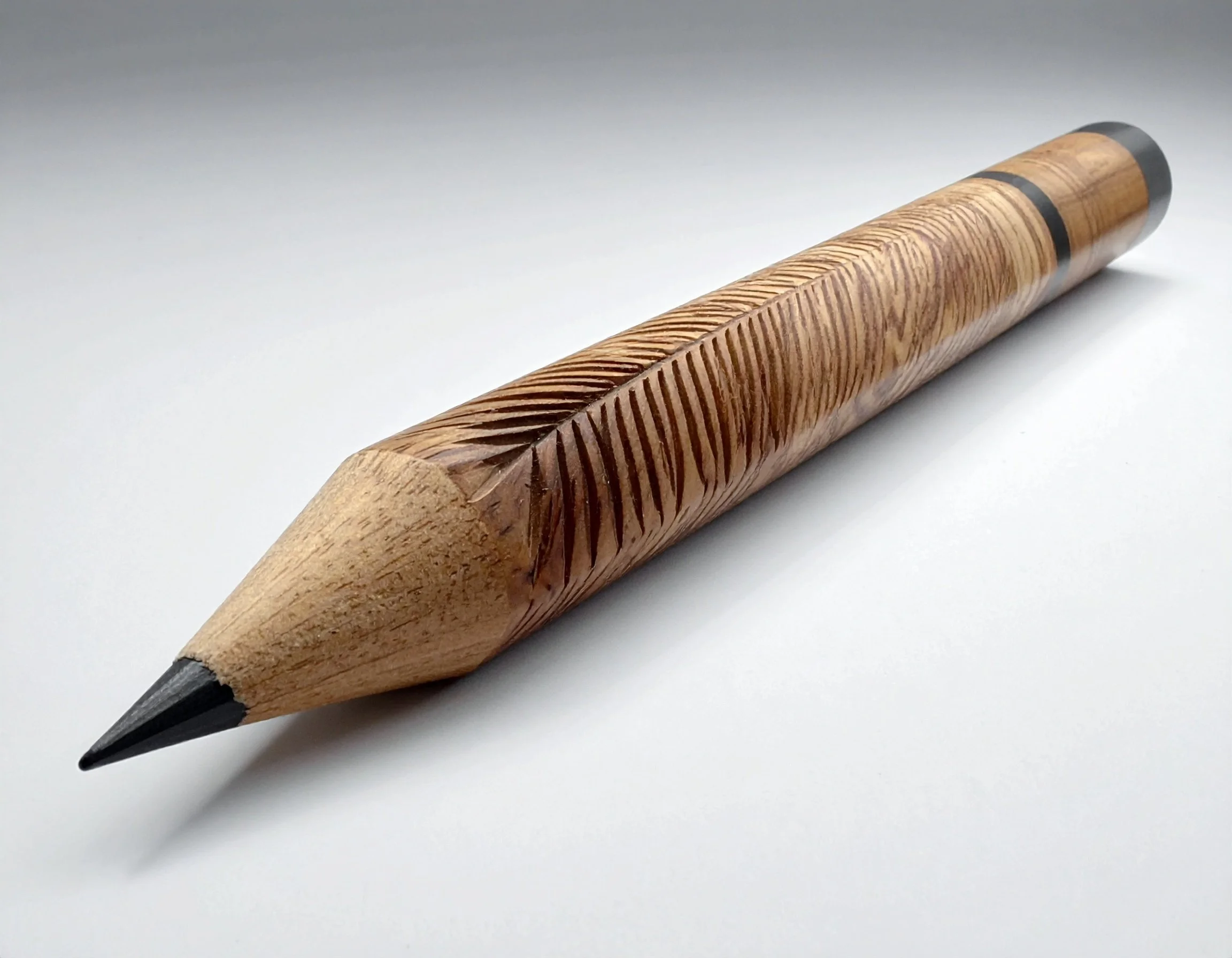 A wooden pencil with carved grooves in the body, typed tip, and a black eraser