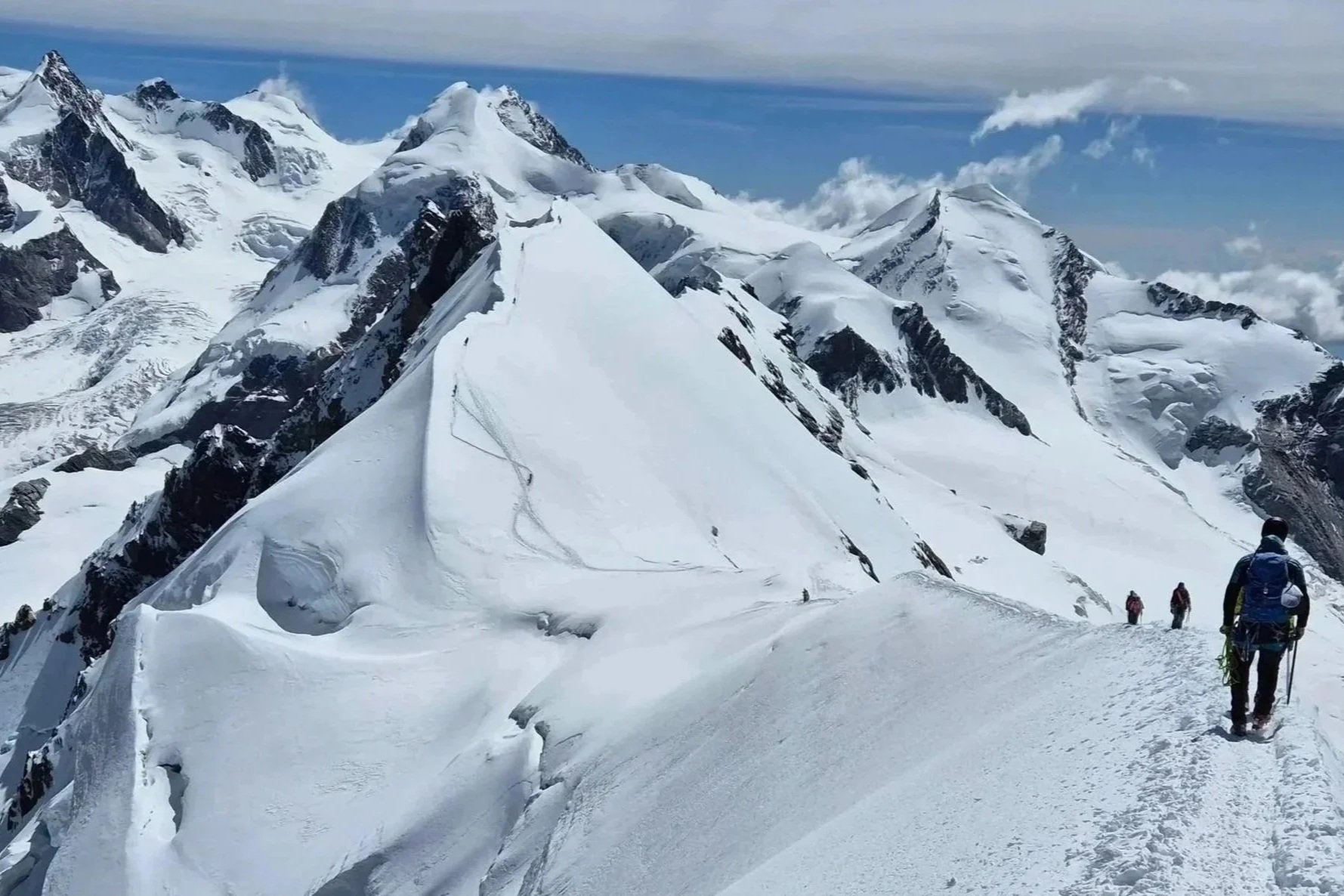 Menschen wandern auf schneebedecktem Berggipfel in den Alpen