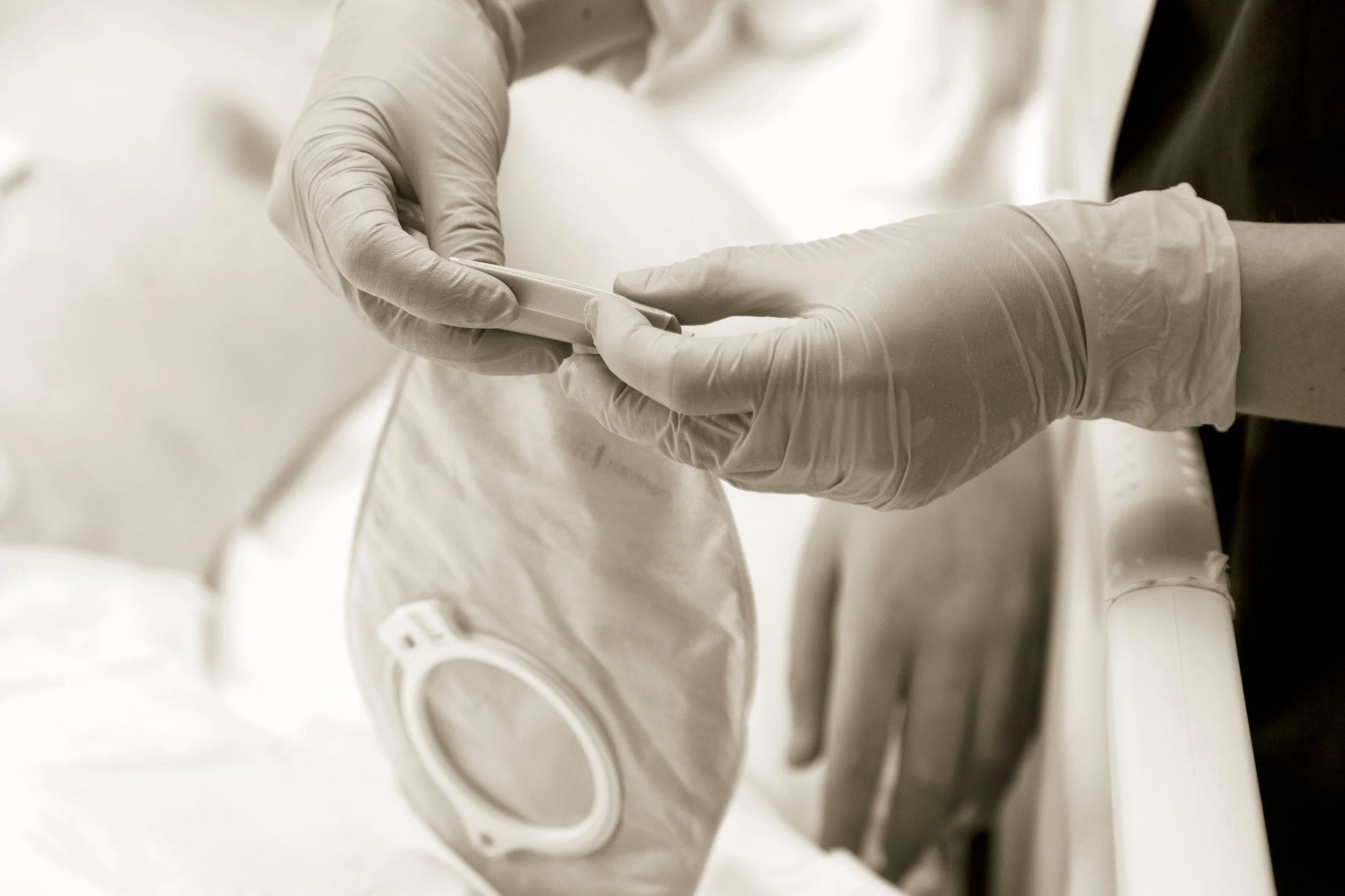Person wearing gloves preparing a sterile mask for medical use.