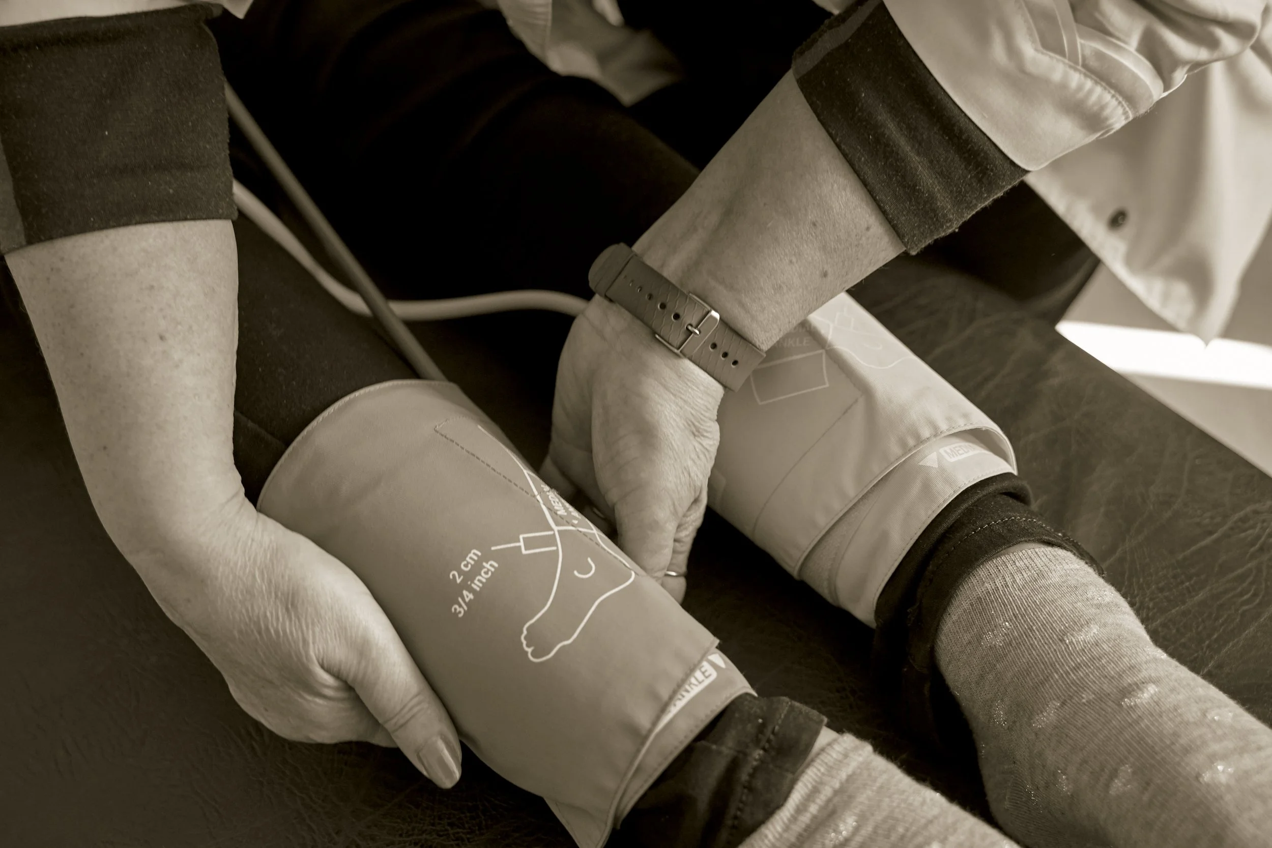 Medical professional measuring a patient's blood pressure with a sphygmomanometer.