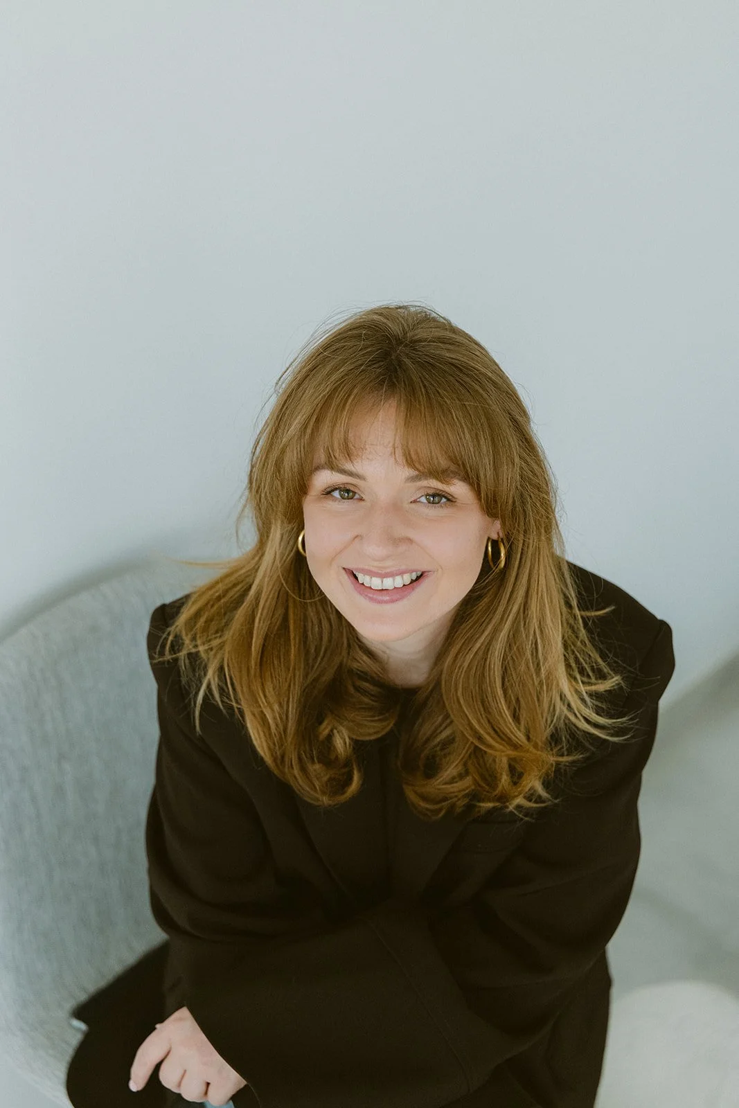 Femke van sorae in business attire; een lachend portret van de coach en bezielster achter sorae die staat voor authentiek ondernemerschap en vrouwelijke balans.