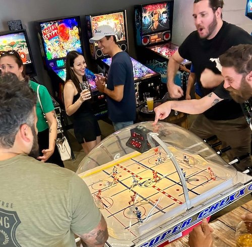 Adults cheering and having fun playing bubble hockey