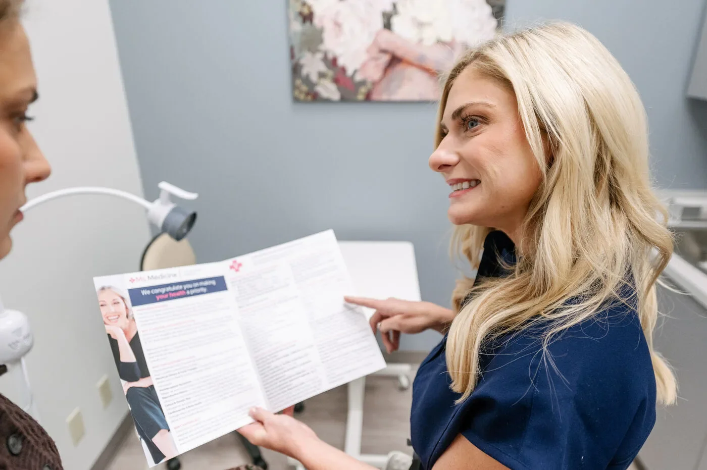Maggie Theriot reviewing patient education materials with a patient in an exam room