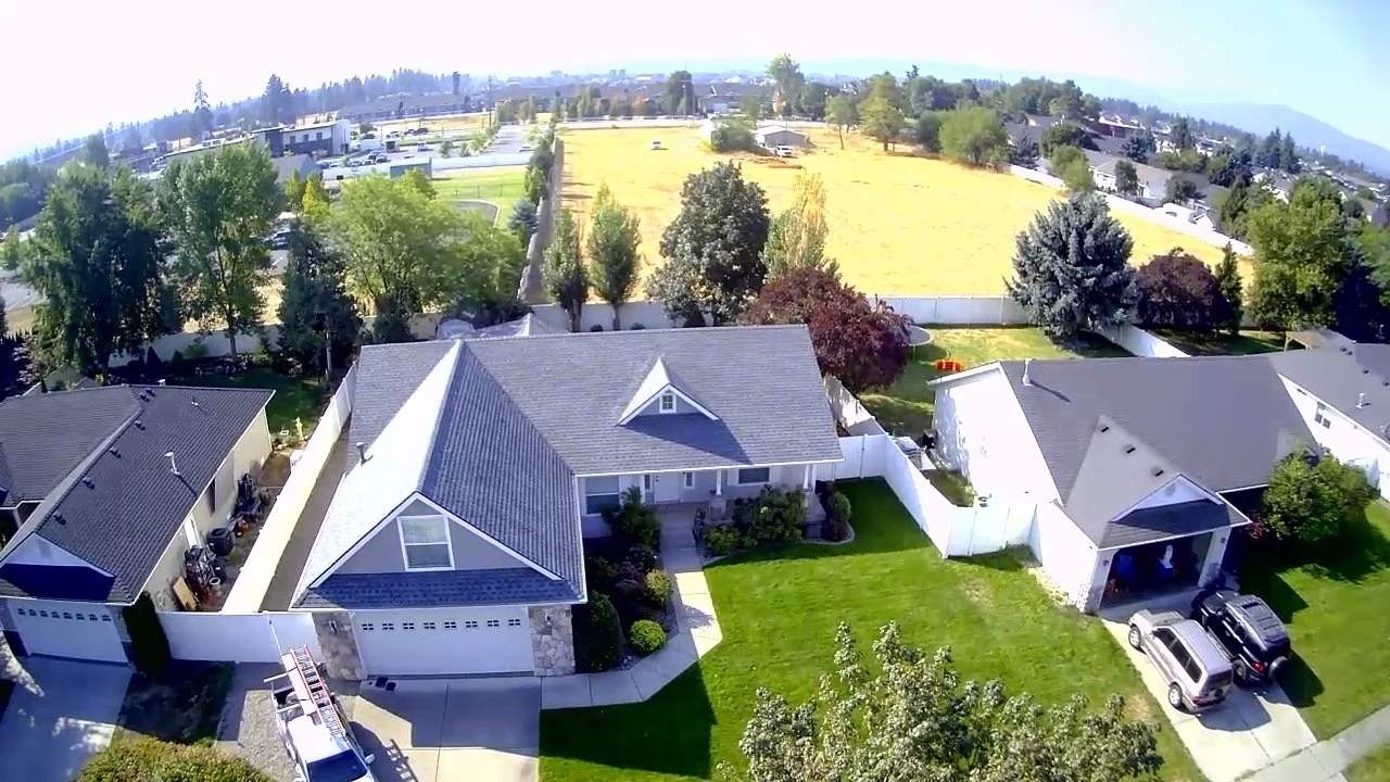Aerial view of a North Idaho residential neighborhood featuring asphalt shingle roofing installed and serviced by Willenborg Roofing.