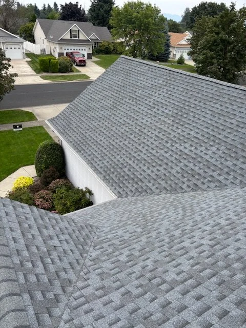 Residential asphalt shingle roofs in a North Idaho neighborhood, highlighting dependable roofing solutions.