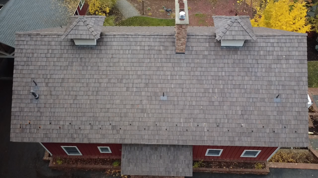 Aerial drone footage view of a historic Red Barn roof restoration completed by Willenborg Roofing in Hayden, Idaho.