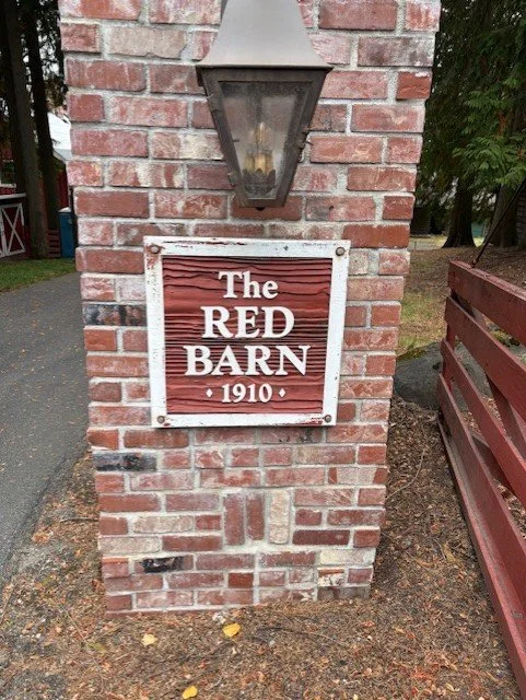 Historic Red Barn 1910 landmark sign at a restored property in Hayden, Idaho.