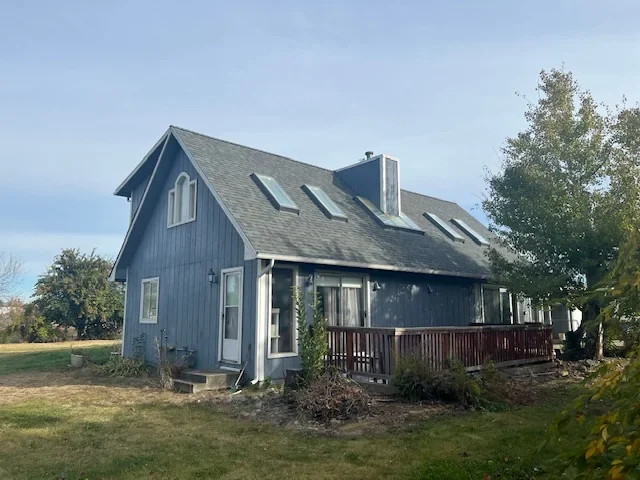 Two-story North Idaho home with a steep-slope asphalt shingle roof and skylights, showcasing quality residential roofing.