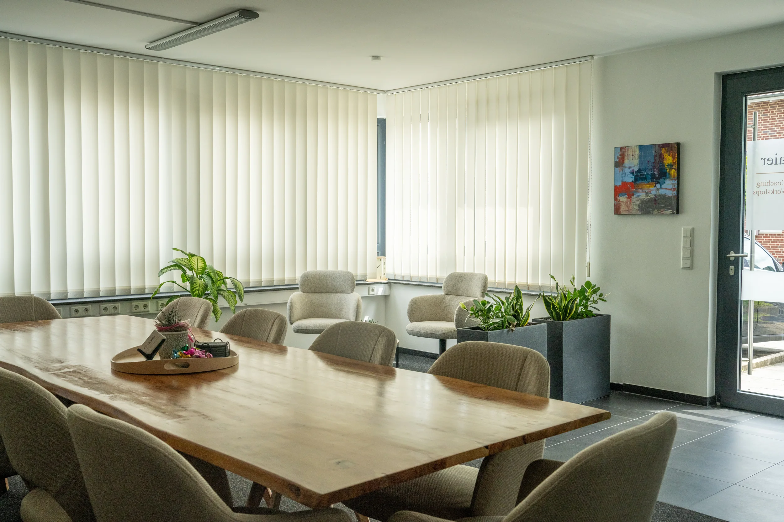 Moderner Besprechungsraum in Münster von Kainz & Maier GbR: Großzügiger Holztisch, bequeme Stühle, helle Fensterfront und inspirierende Kunstwerke. Mietbar für Coachings und Gruppenmeetings.