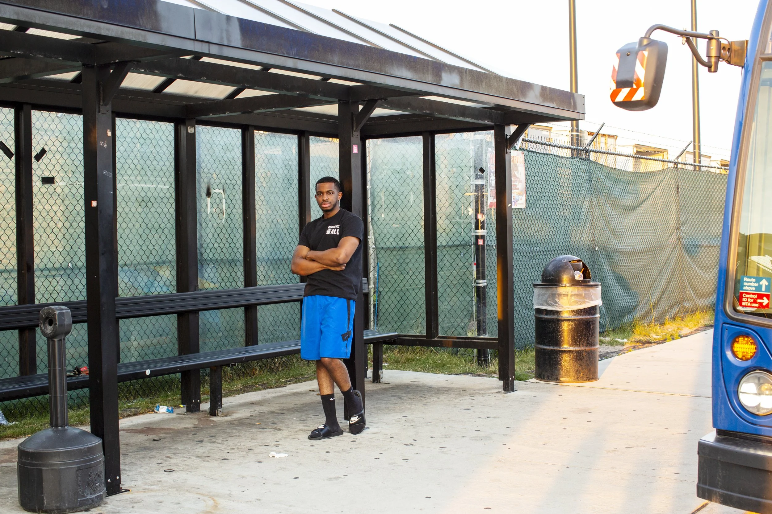 Derrick Palmer poses by a bus stop near an Amazon facility in Staten Island.