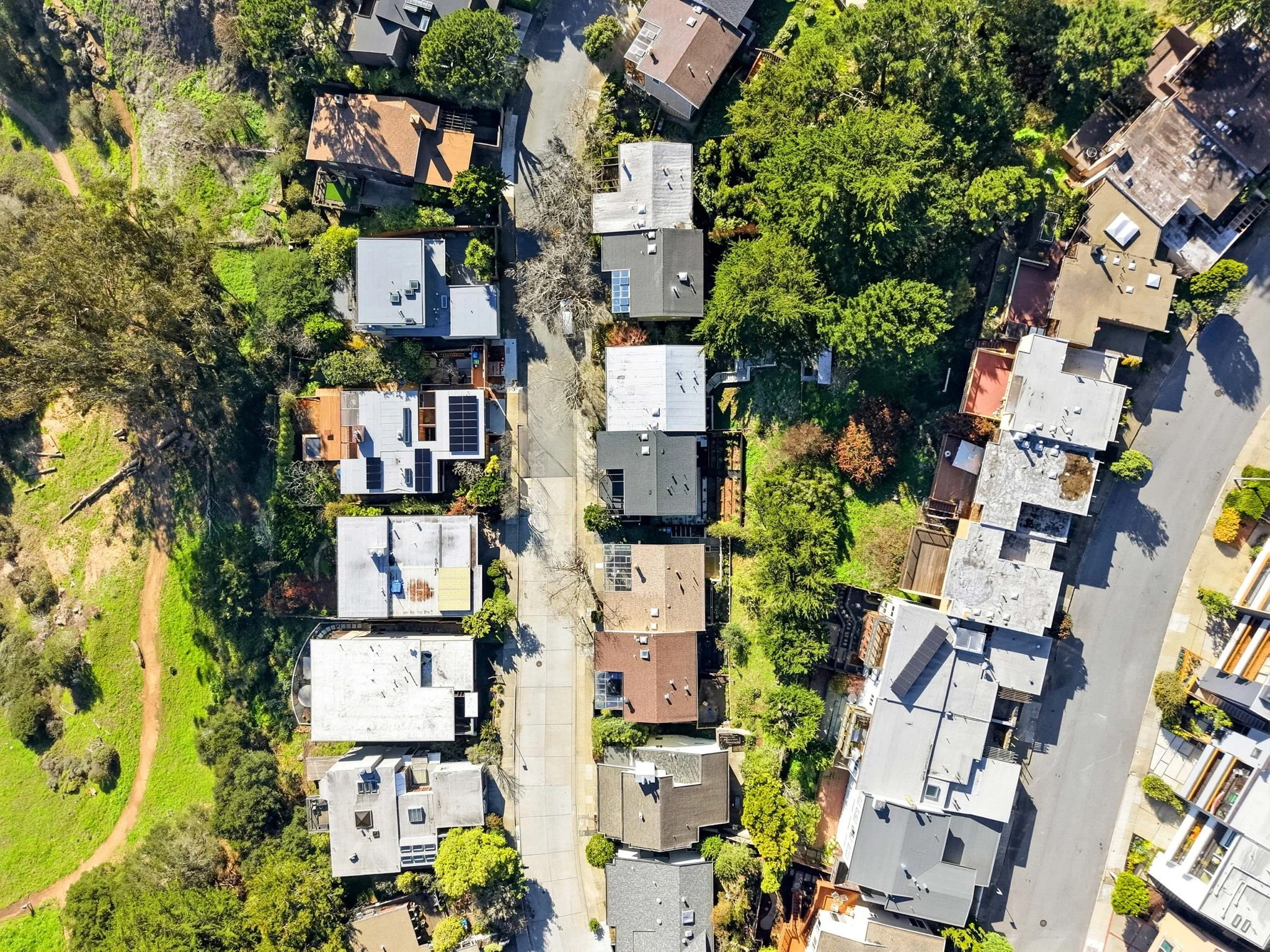Aerial view of a residential neighborhood with houses, trees, and a curved street.