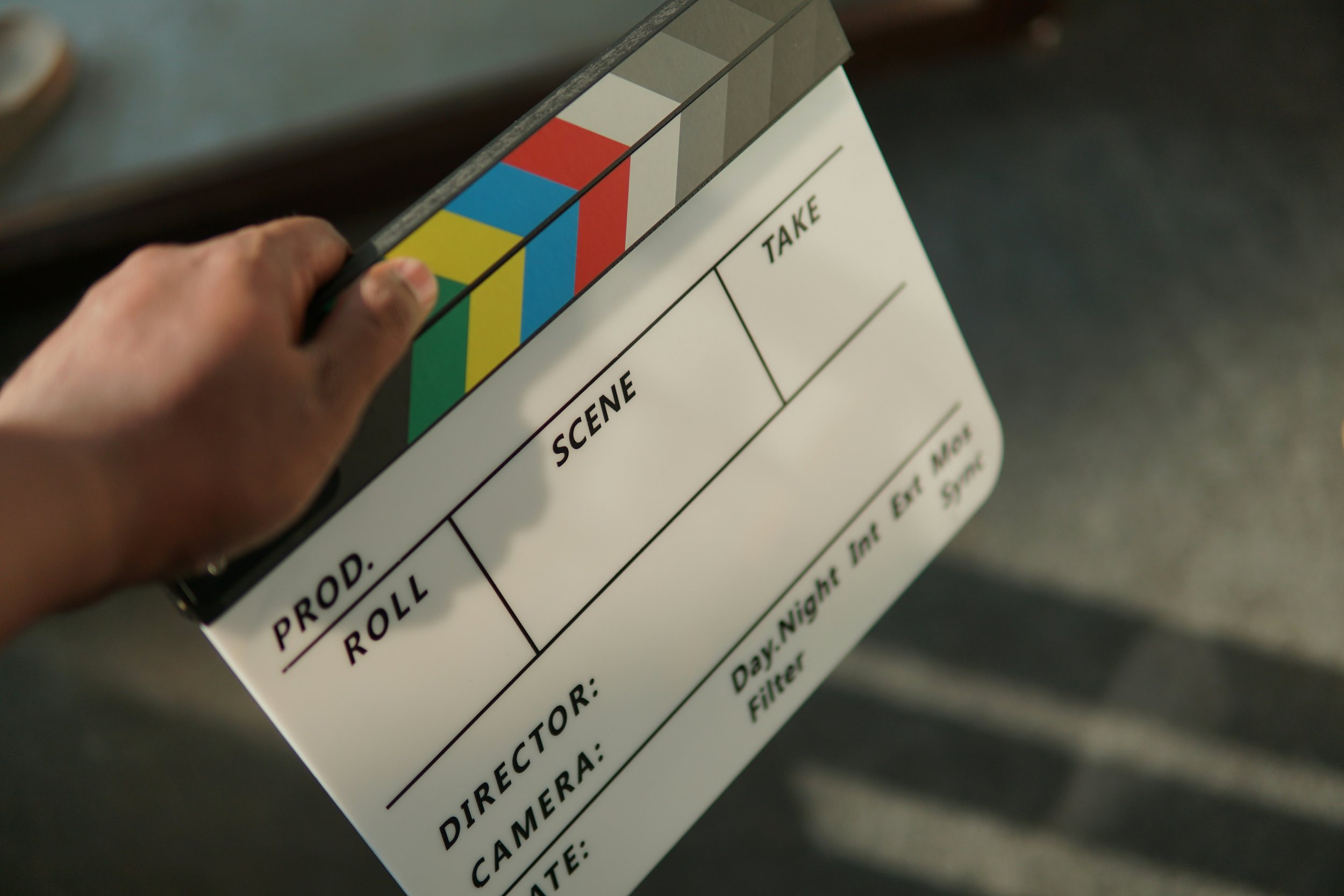 A mountain landscape with snow-capped peaks and green rolling hills, featuring a small building or house on the hillside.